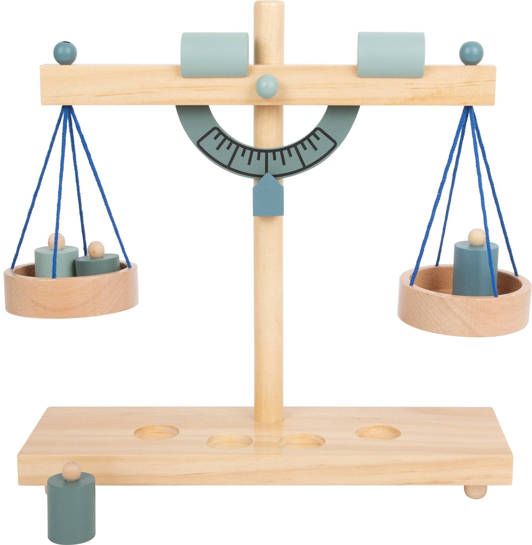 Eine Holzwaage-Spielzeugs mit zwei hängenden Schalen, die jeweils blaue Gewichte halten, auf einem Holzständer mit Basis und einem halbkreisförmigen Messgerät montiert.