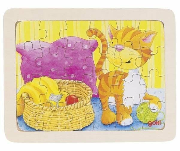 Eine Katze steht neben einem Korb mit einer Maus darin, einem violetten Kissen und einem grünen Wollknäuel auf dem Boden, alles in einem bunten Puzzle dargestellt.