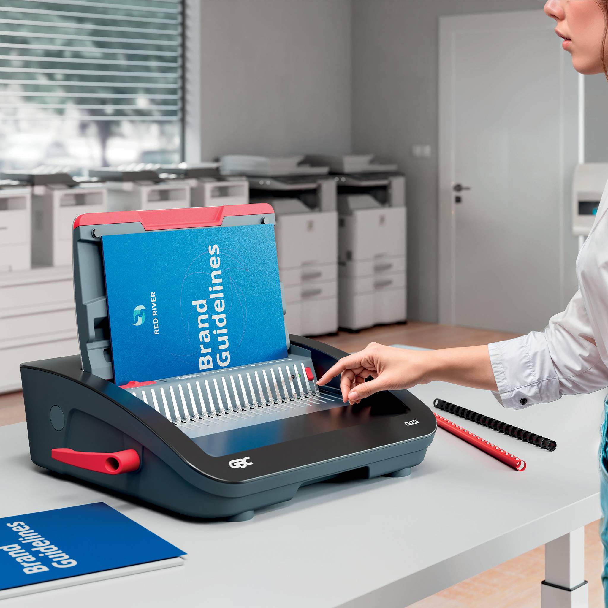 Eine Person bindet ein Booklet mit „Markenrichtlinien
