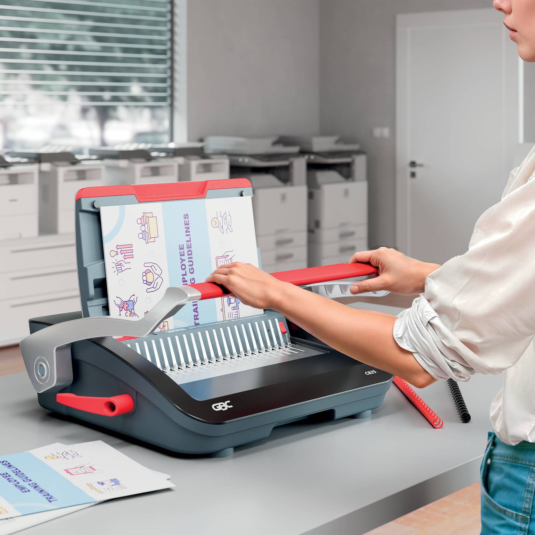 Eine Person verwendet eine Kammbindemaschine, um einen Stapel gedruckter Seiten in einem Büro zu lochen und zu binden.