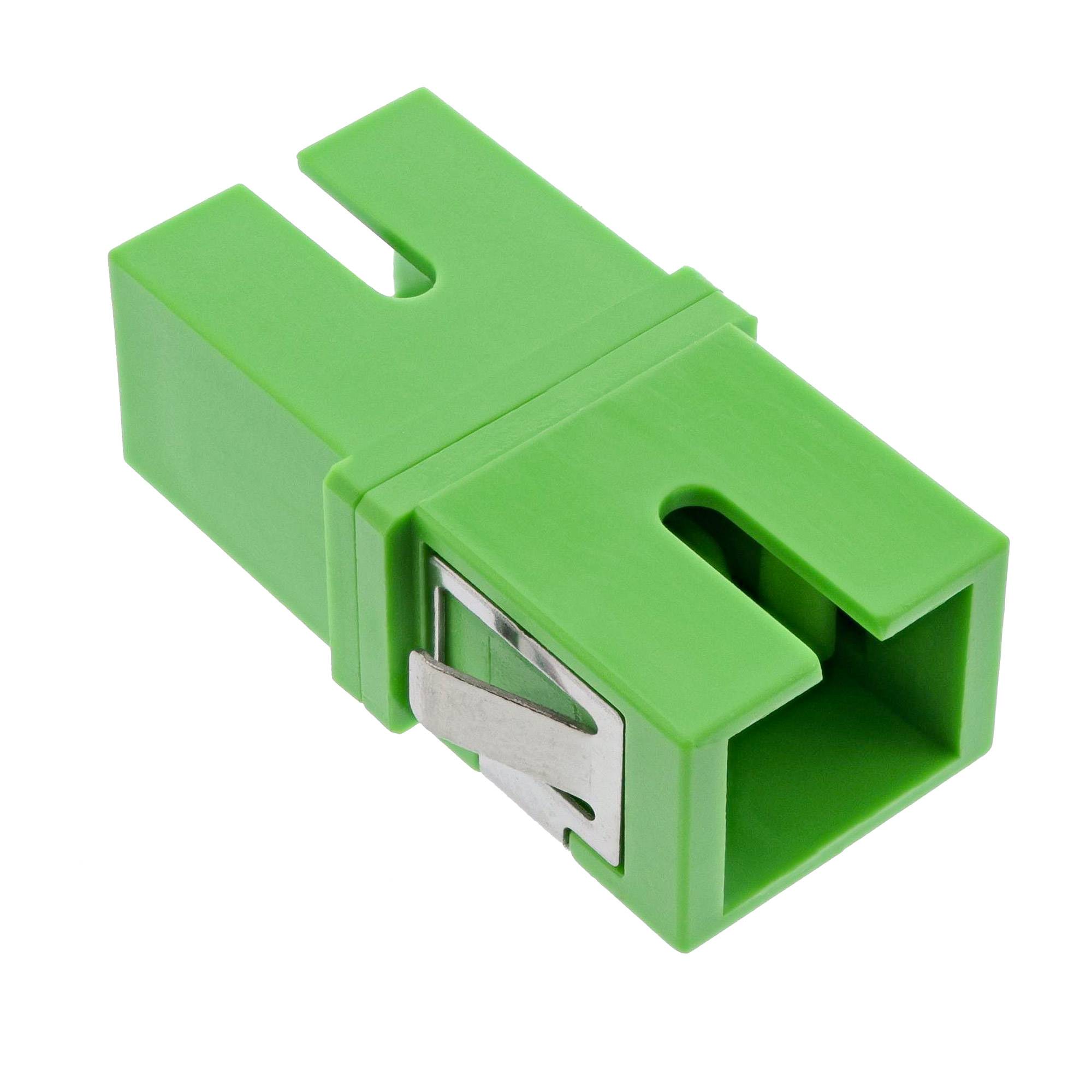 Ein grüner, rechteckiger Glasfaseradapter mit Metallclip, der zum Verbinden und Ausrichten von Glasfaserkabeln verwendet wird.