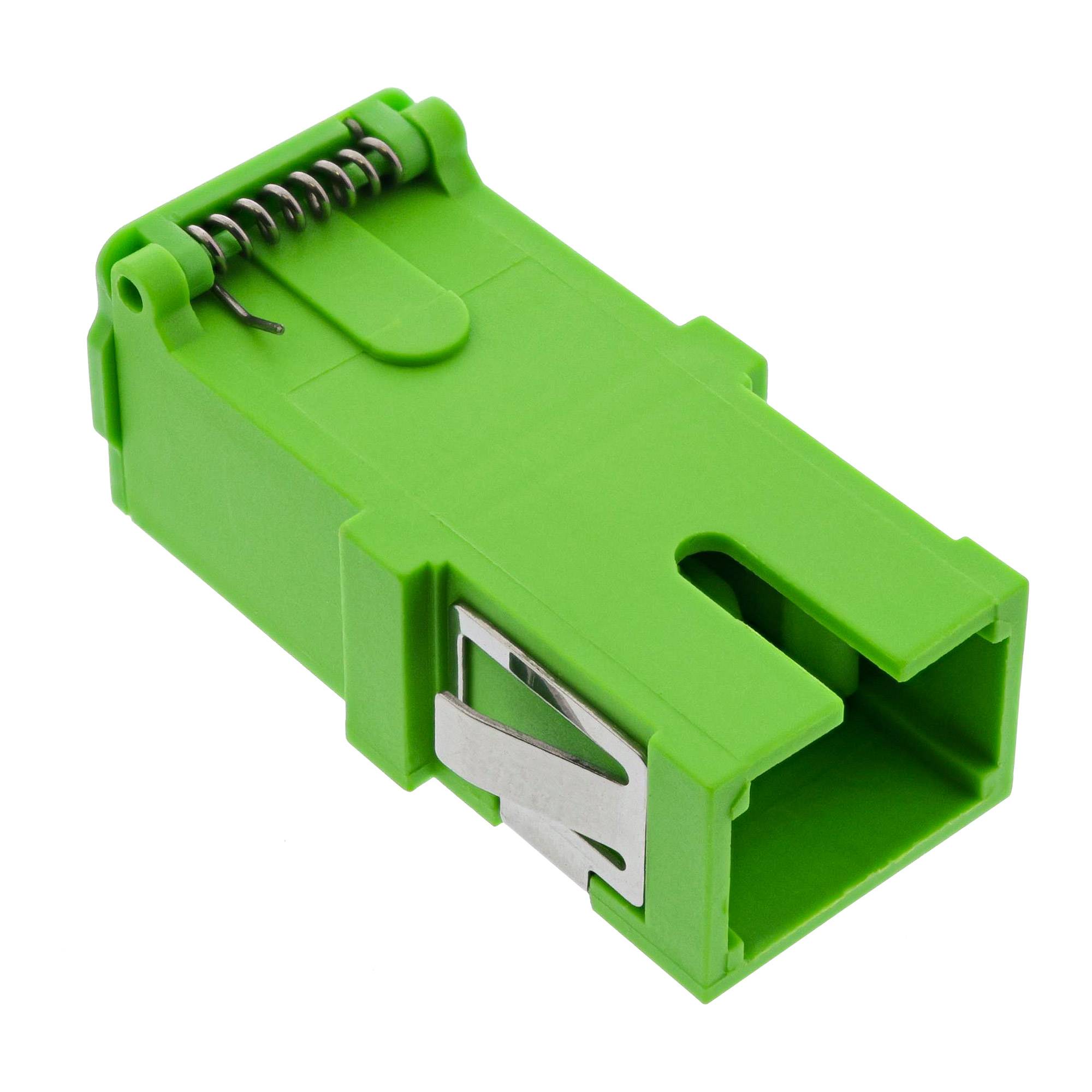 Ein grüner Glasfaseradapter mit einem Metallclip, verwendet zum Anschluss von optischen Kabeln, auf einem weißen Hintergrund.