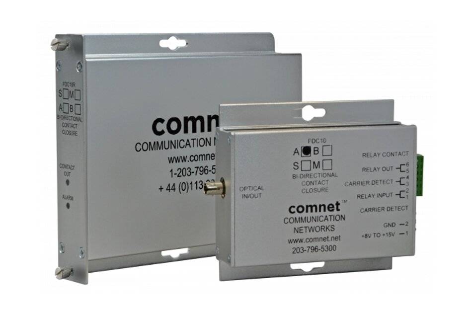 Zwei graue ComNet-Kommunikationsnetzwerk-Metallmodule gestapelt, zeigend optische Ein- und Relais-Kontaktetiketten auf weißem Hintergrund.