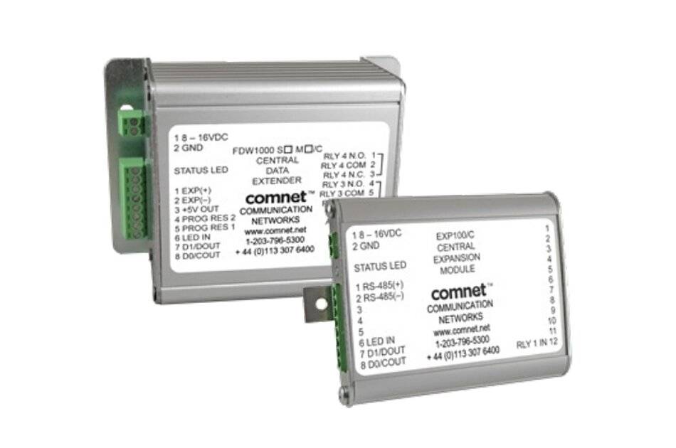 Zwei Comnet-Netzwerkkommunikationsmodule, ein zentrales Datenverstärkermodul und ein Erweiterungsmodul, dargestellt als Industriemetallgeräte mit gekennzeichneten Klemmblöcken.