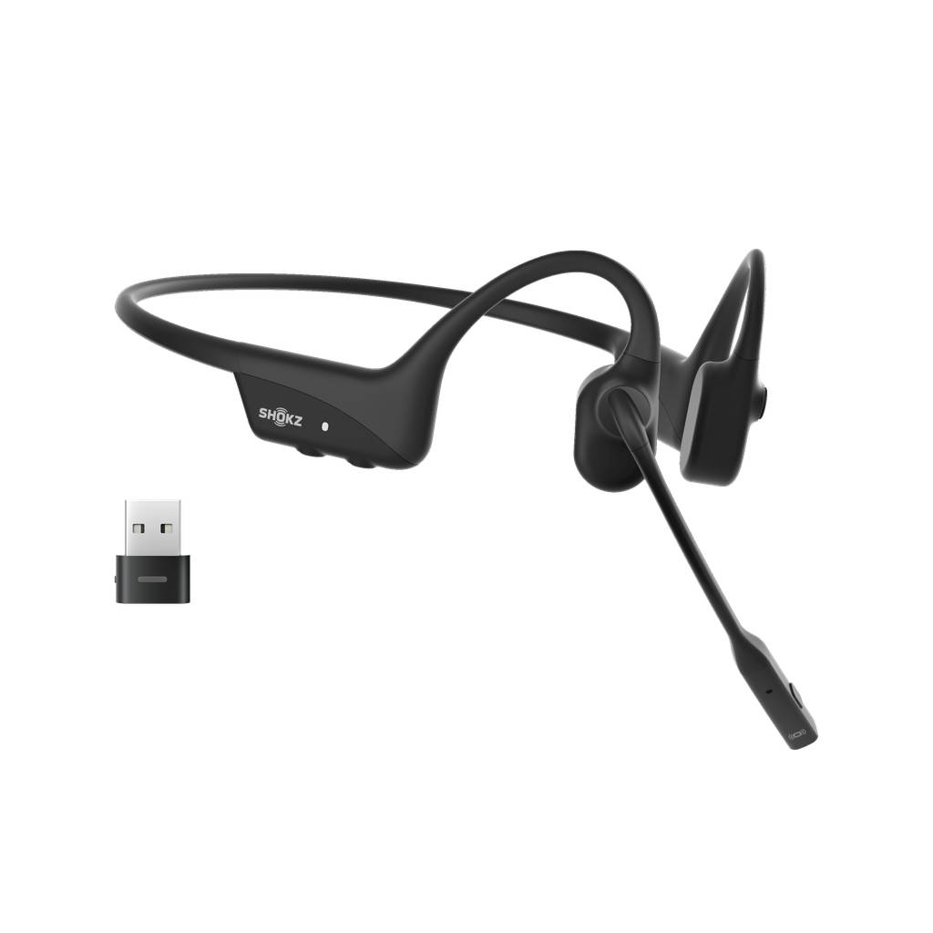 Schwarzes Shokz kabelloses Open-Ear-Headset mit Boom-Mikrofon und USB-Dongle auf schwarzem Hintergrund.