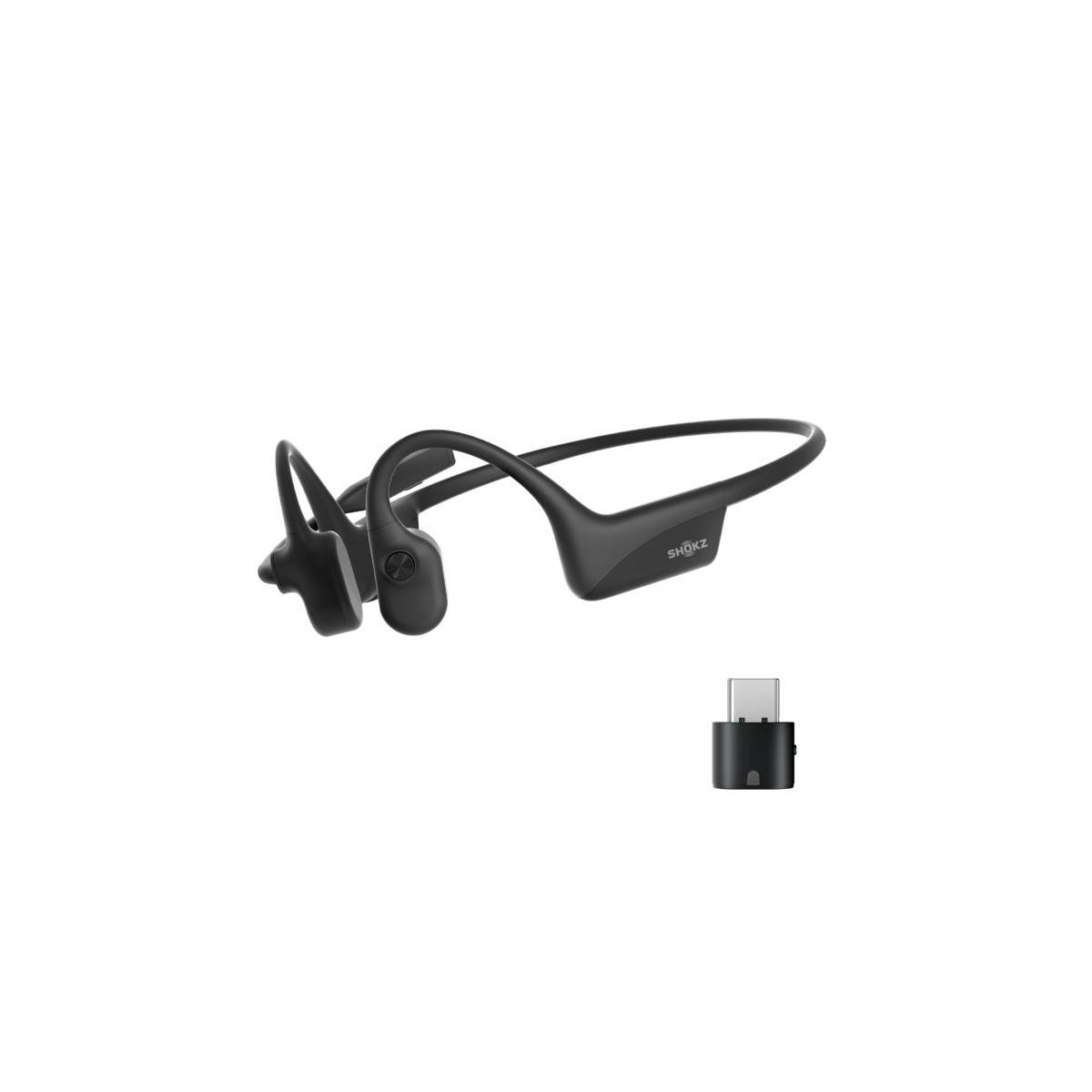 Schwarze kabellose Kopfhörer mit Knochenschall und offenem Ohr-Design, zusammen mit einem kleinen USB-C-Adapter für die Konnektivität.