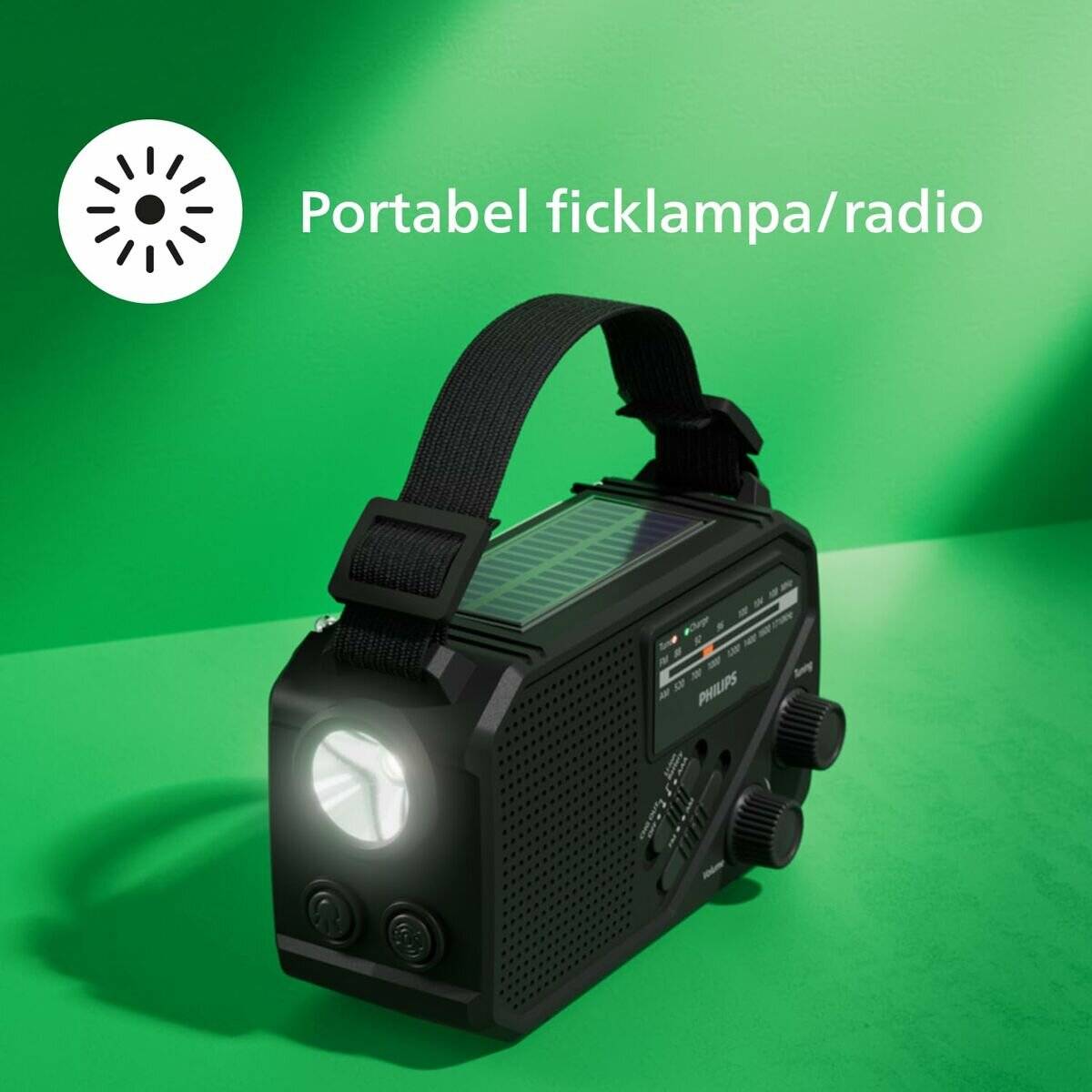 Schwarze tragbare Taschenlampe/Radio mit Riemen und leuchtender Frontlampe auf grünem Hintergrund, beschriftet mit 