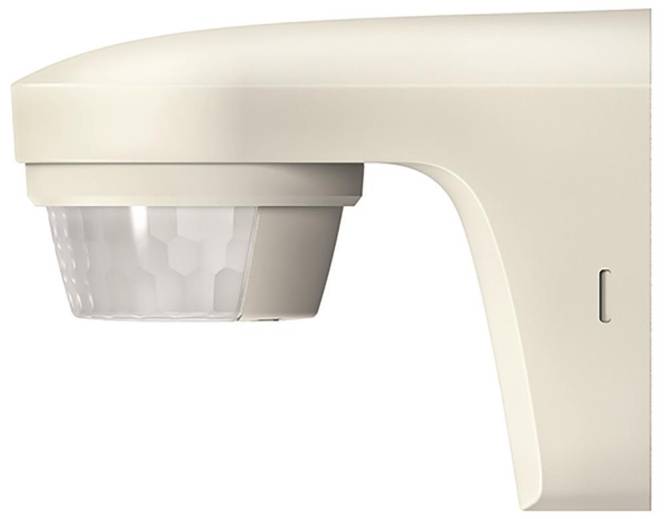 Eine Nahaufnahme eines weißen Bewegungsmelders mit einer sechseckigen Linse, an einer Wand montiert, wird zur Erkennung von Bewegungen in einem Raum verwendet.