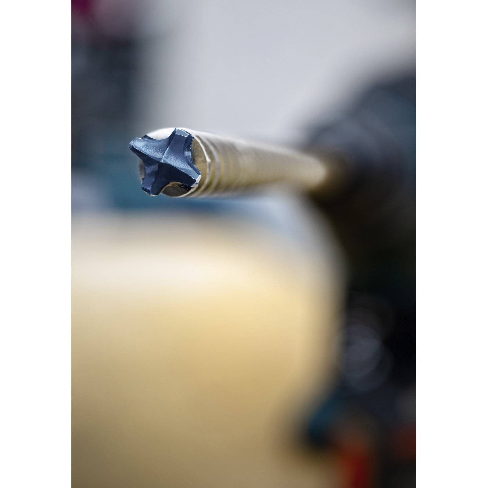 Ein Nahaufnahmebild eines Metallbohrers mit einer fokussierten Spitze. Der Hintergrund ist unscharf, wodurch die Schärfe und Einsatzbereitschaft des Werkzeugs betont wird.