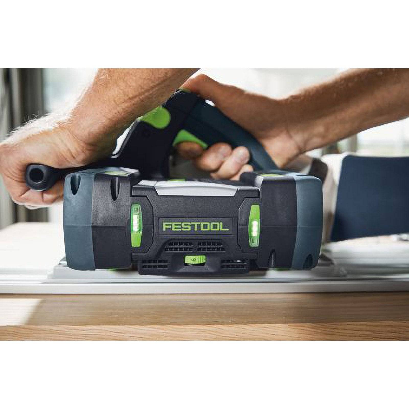 Person, der eine Festool Akku-Kreissäge auf einer Holzoberfläche verwendet und präzises Schneiden mit ergonomischem Design demonstriert.
