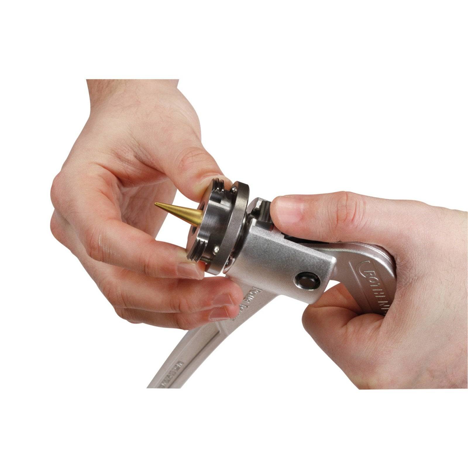Zwei Hände demonstrieren die Anpassung eines metallischen Werkzeugs mit einer spitzen Düse und zeigen, wie dessen Befestigung verändert oder gesichert wird.