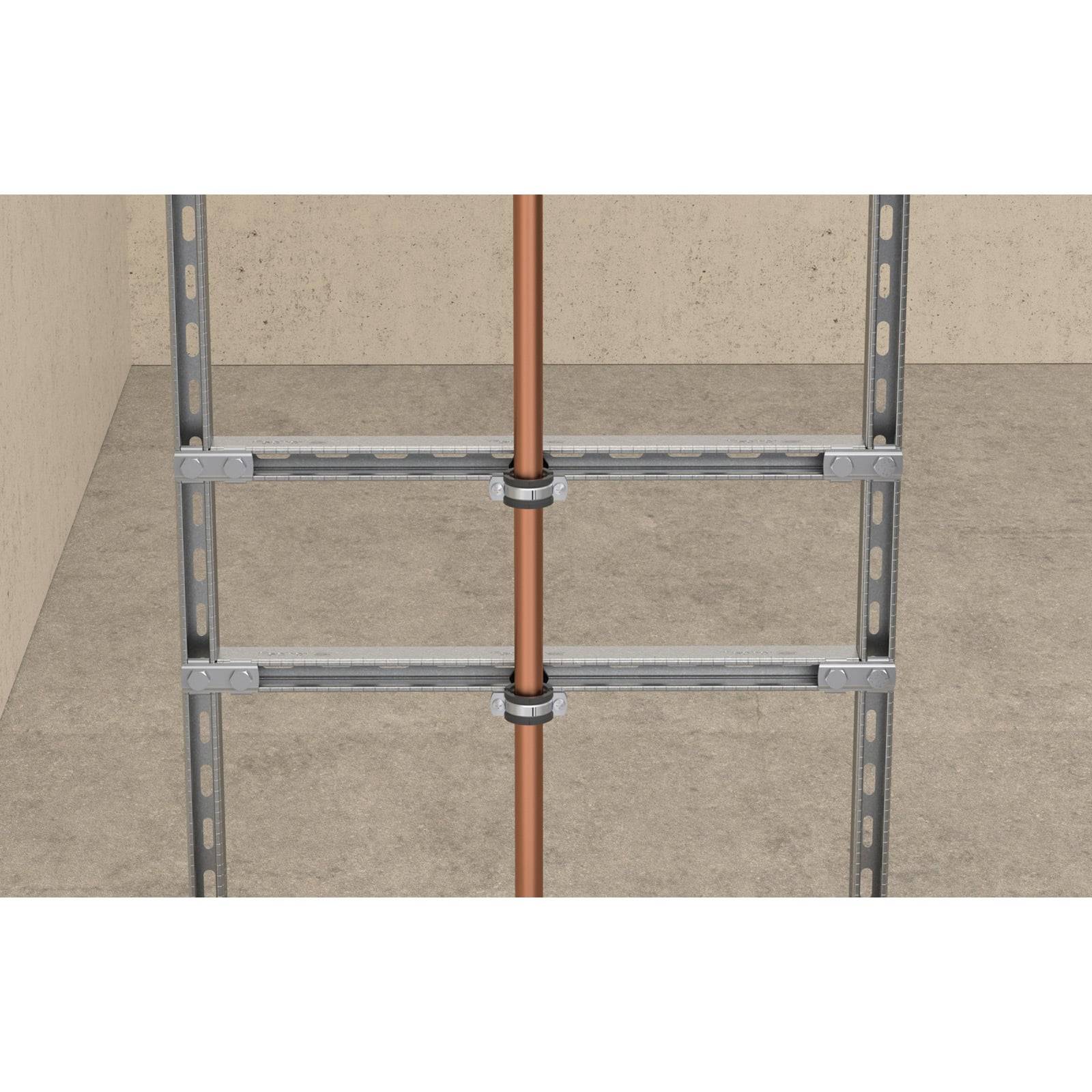 Kupferrohr, gesichert durch Metallhalterungen in einem Strukturrahmen an einer schlichten Wand, zeigt die Abstützung einer Sanitärinstallation.