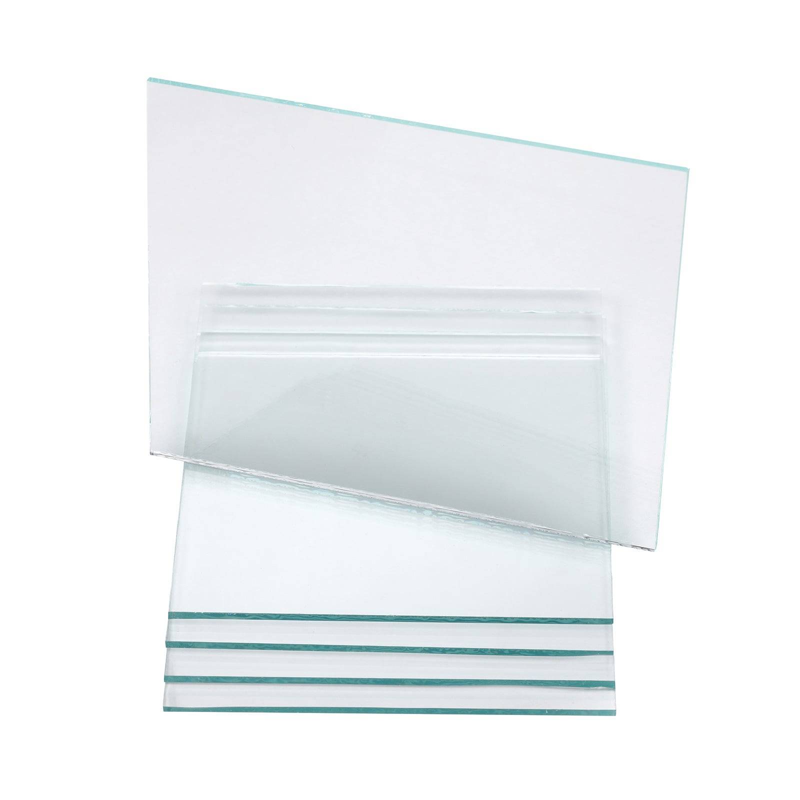 Ein Stapel durchsichtiger Glasscheiben in verschiedenen Größen, in Schichten angeordnet. Die oberste Scheibe ist leicht geneigt und zeigt ihre Transparenz und Dicke.