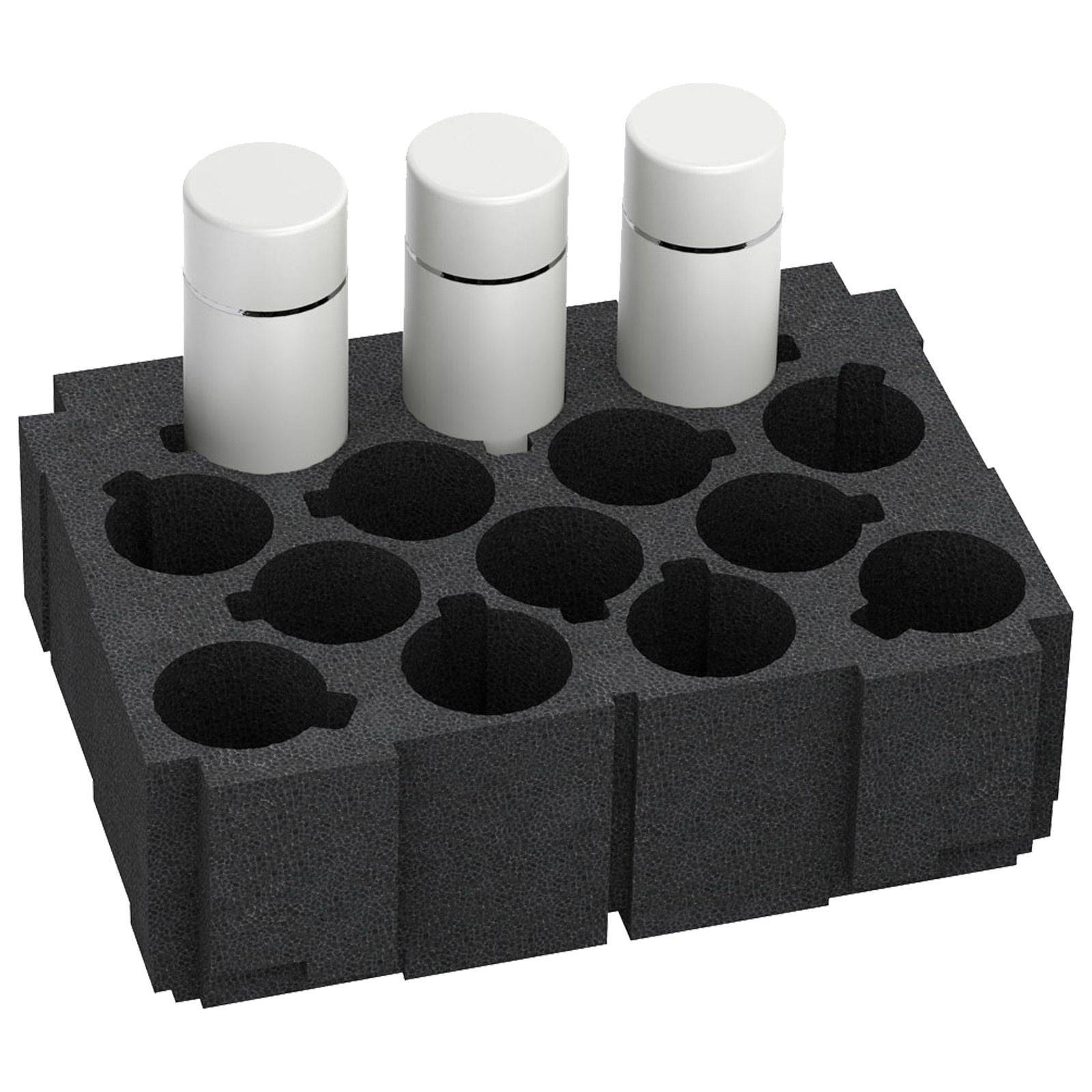 Schwarzer Schaumstoffeinsatz, der drei weiße zylindrische Objekte an ihrem Platz hält. Mehrere leere Fächer sind für weitere Gegenstände verfügbar.