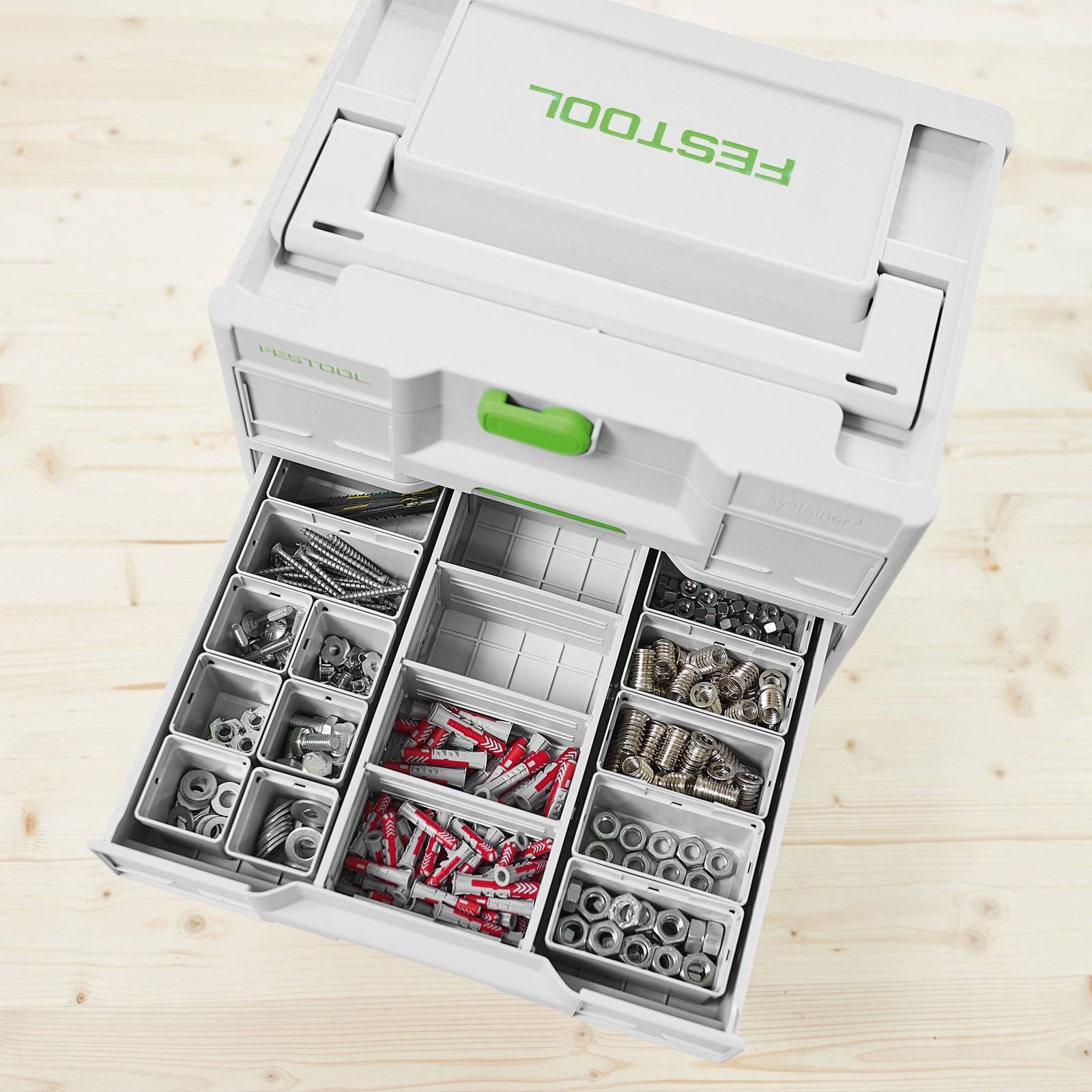 Eine weiße Kunststoff-Sortierbox ist geöffnet und zeigt mehrere Fächer, die mit verschiedenen Schrauben, Metallteilen und roten Dübeln gefüllt sind.