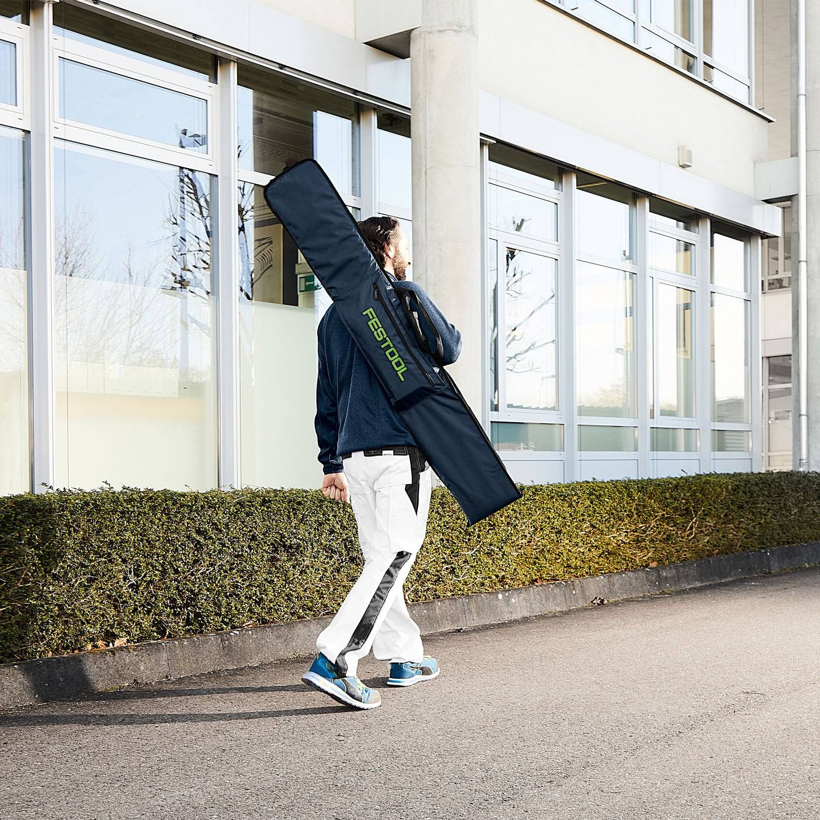 Eine Person trägt eine lange rechteckige Tasche mit der Aufschrift 