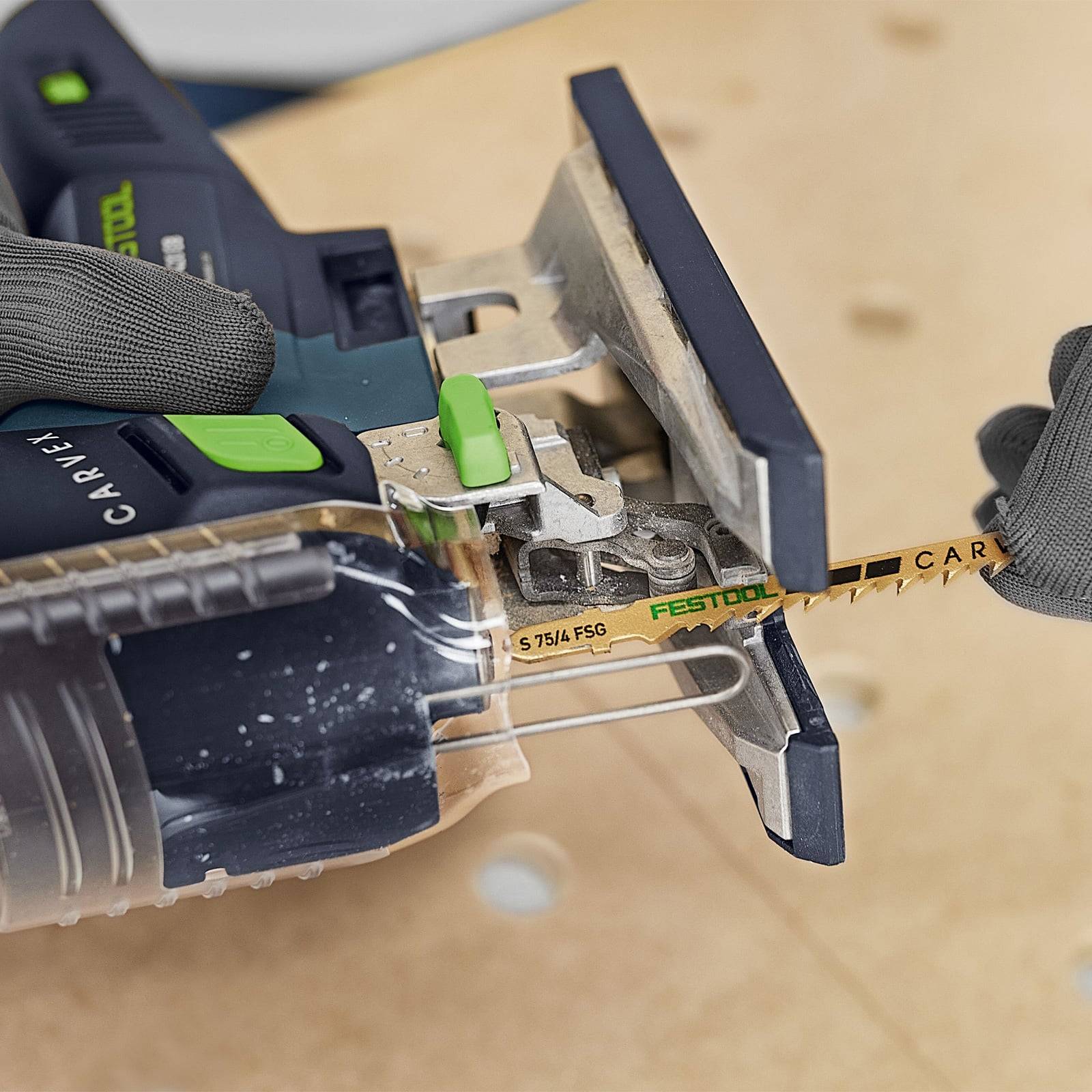 Eine Person, die eine Stichsäge verwendet, um eine gerade Linie in Holz zu schneiden, wobei präzise Kontrolle mit Händen in Handschuhen hervorgehoben wird.