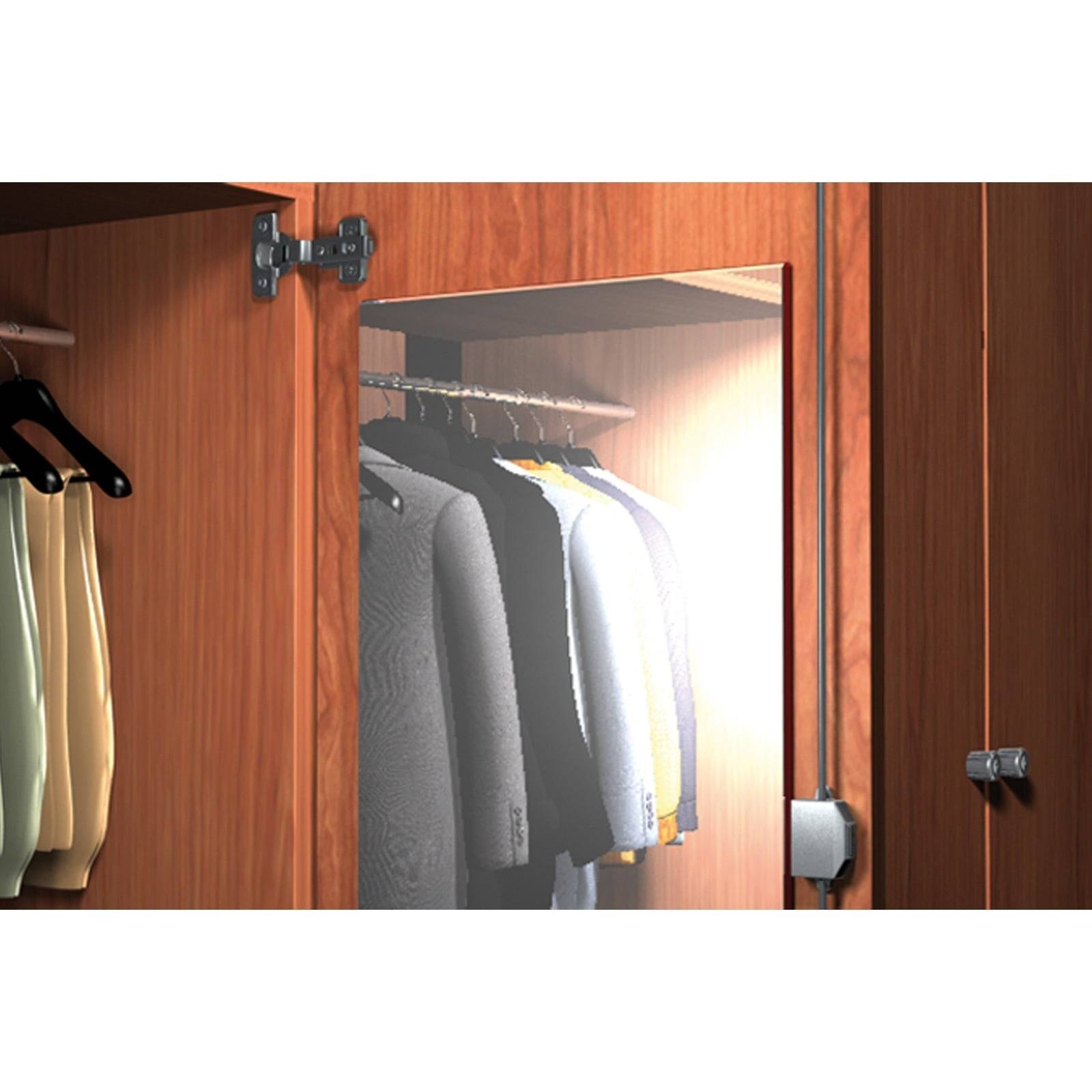 Ein beleuchteter Holzkleiderschrank mit offenen Türen zeigt eine Reihe von ordentlich aufgehängten Jacken und Hemden an Kleiderbügeln im Inneren.