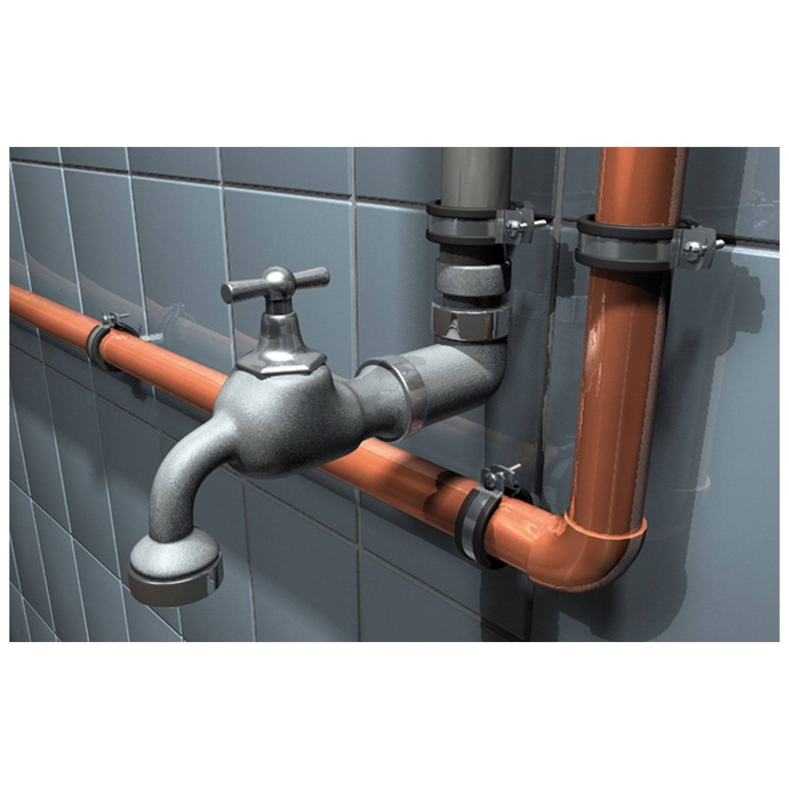 Ein Metallhahn, der an Kupferrohren befestigt ist und an einer gefliesten Badezimmerwand montiert ist.