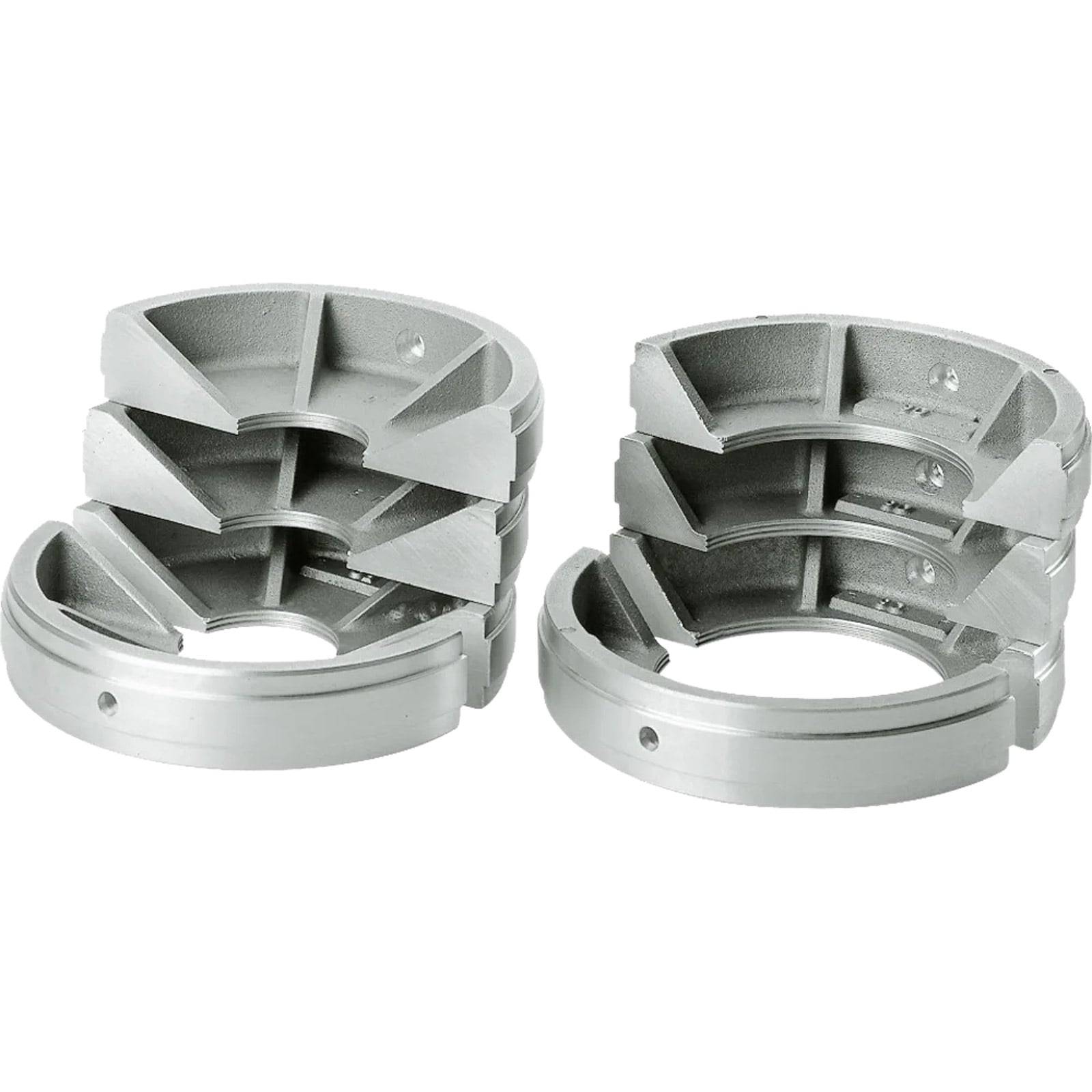 Zwei metallische, segmentierte Komponenten, die jeweils kreisförmige Öffnungen und gewinkelte Schlitze aufweisen, möglicherweise für mechanische Zwecke oder zur Montage verwendet.