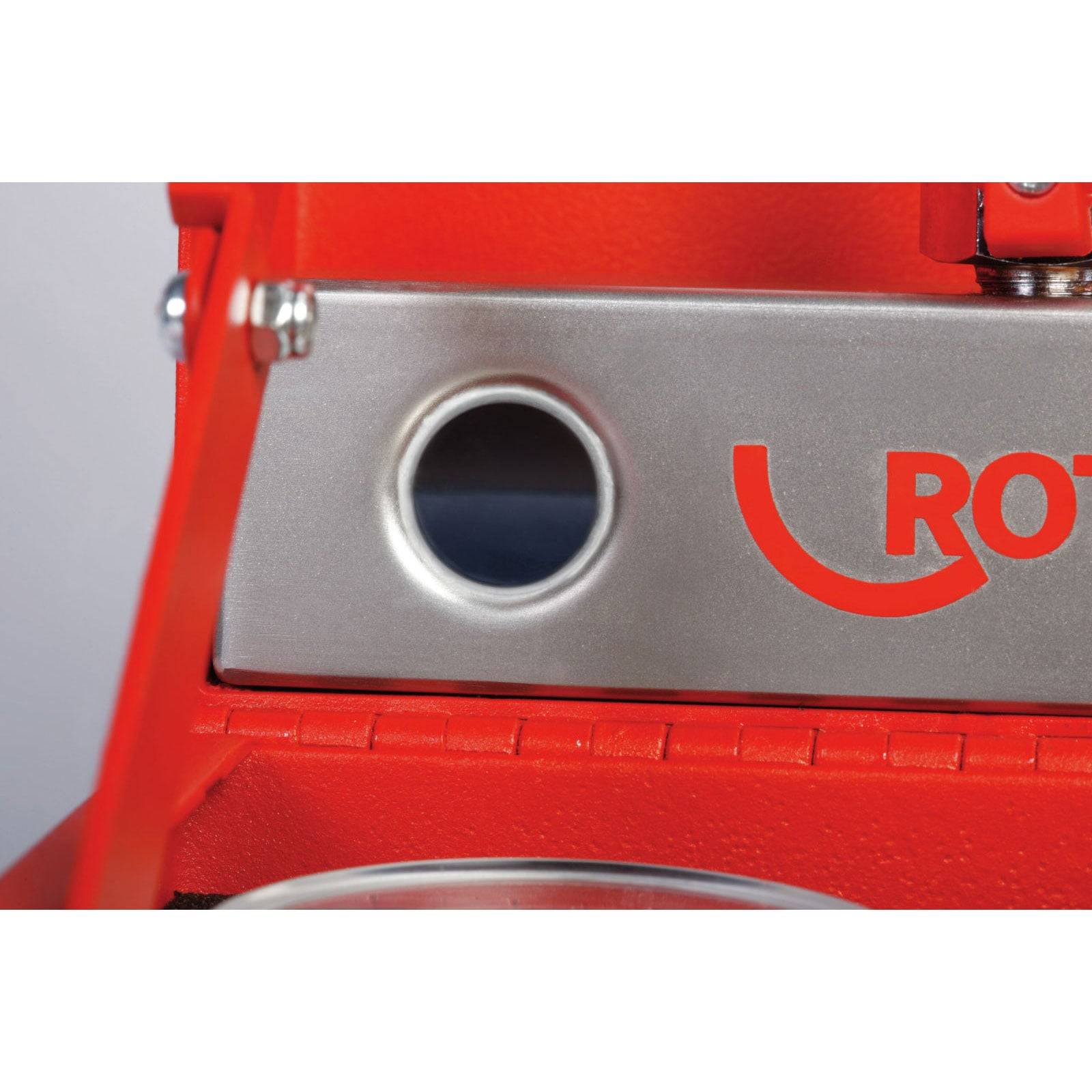 Eine Nahaufnahme einer Maschine mit einer kreisförmigen Öffnung und einem roten 'ROT'-Logo. Die Maschine ist überwiegend grau und orange.