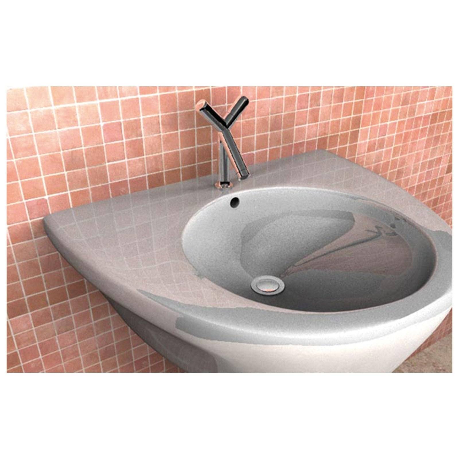 Ein grauer Waschbecken mit einer geschwungenen Mulde und einer modernen Armatur ist an einer rosa gekachelten Wand montiert.