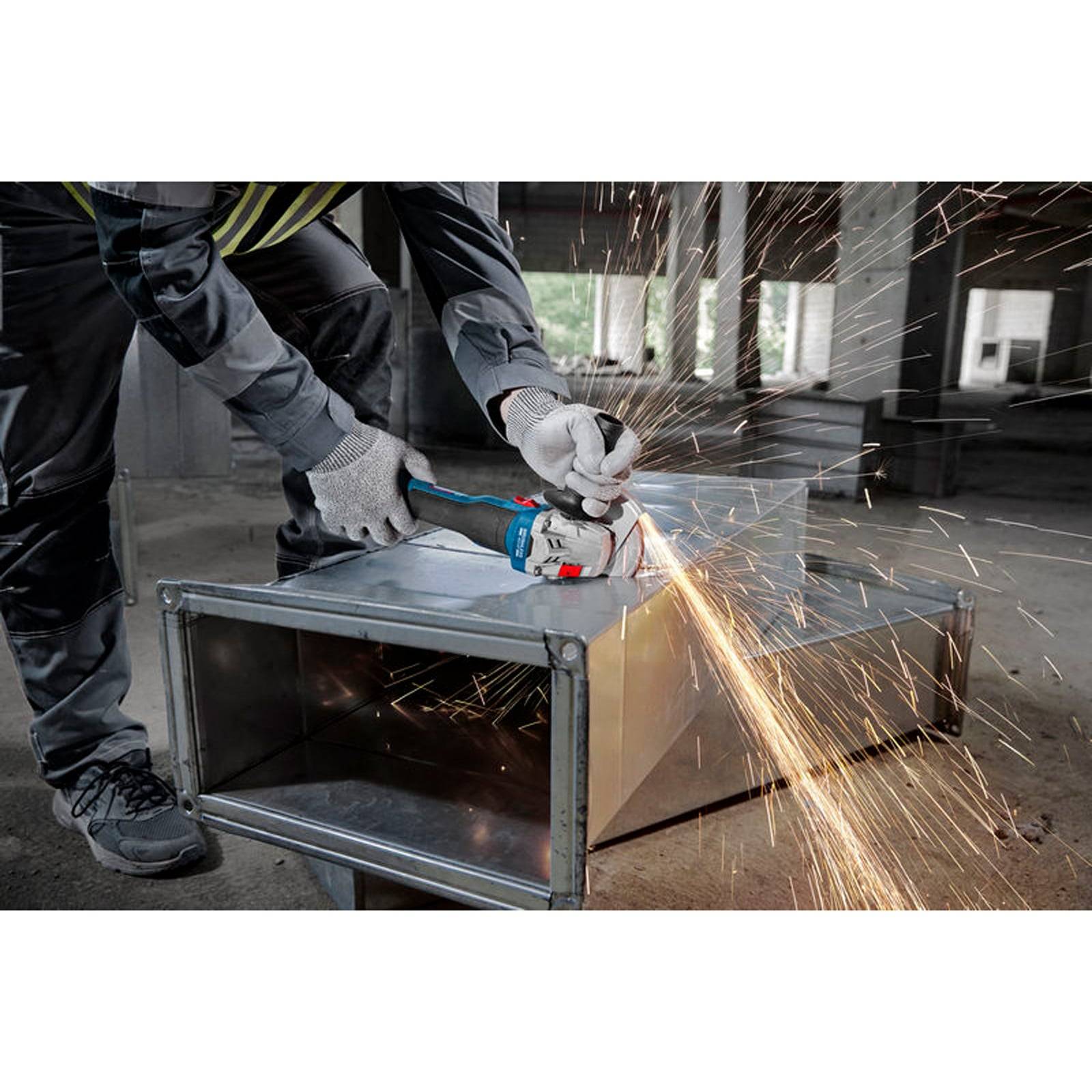 Ein Arbeiter in Schutzausrüstung benutzt einen Winkelschleifer auf Metall, wobei Funken sprühen, in einem industriellen Umfeld.