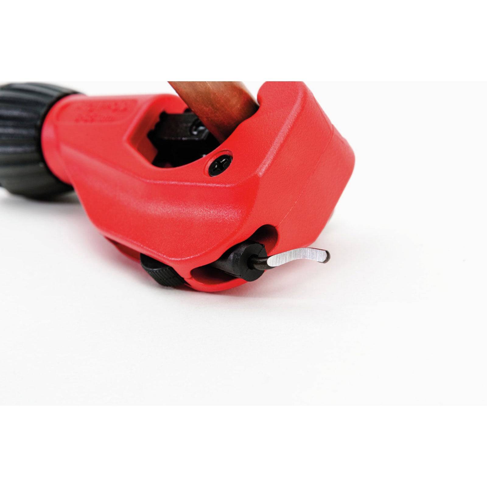 Roter Rohrabschneider, der ein Kupferrohr umfasst und zeigt Klinge und Einstellknopf.