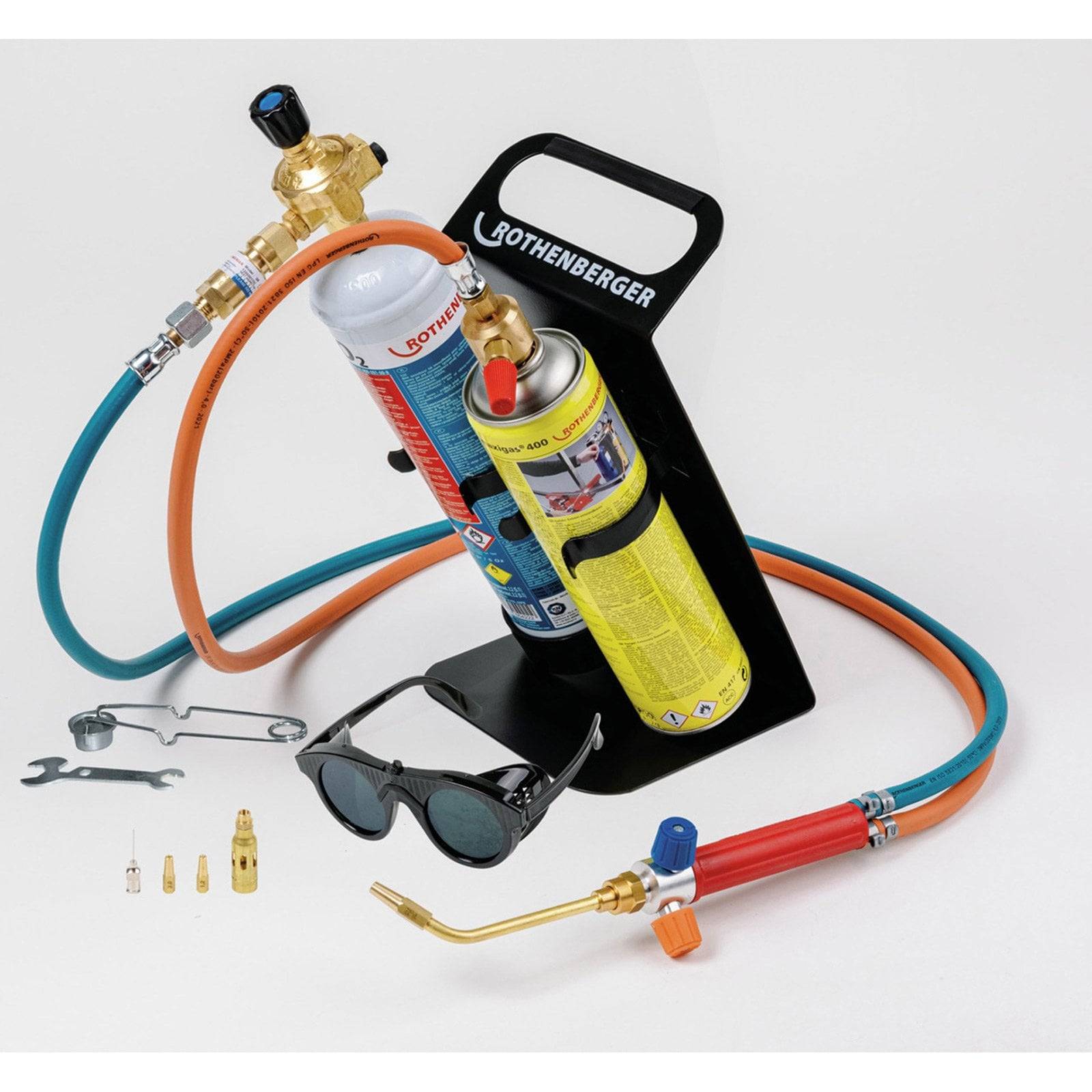 Ein Lötbrenner-Set mit Gaspatronen, Düsen, Schläuchen, Schutzbrille und Schraubenschlüssel, ausgestellt auf einem Halter mit „Rothenberger