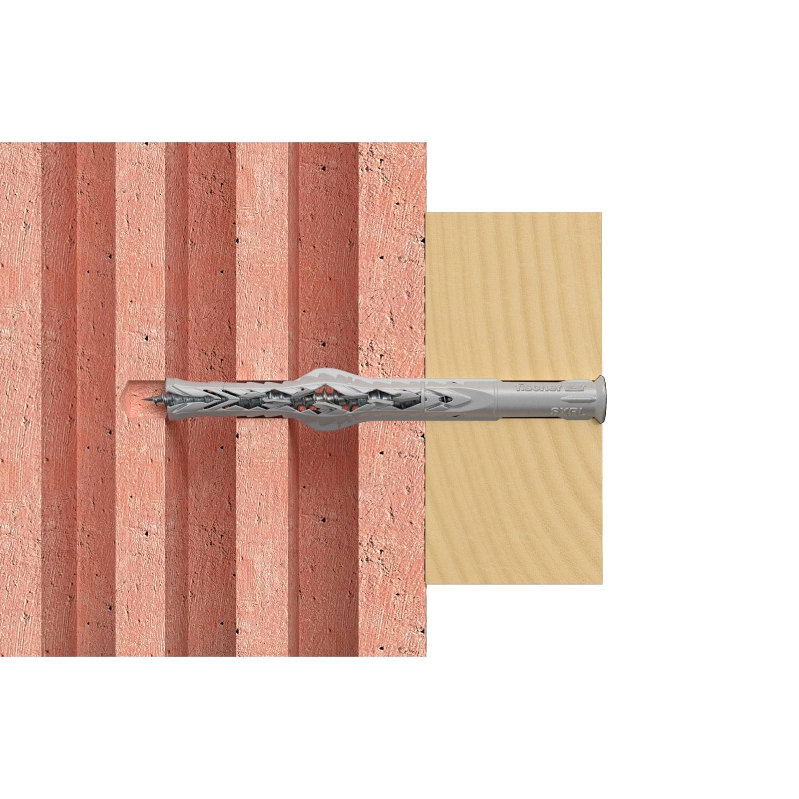 Eine Bohrerspitze, die sich in eine Ziegelwand bohrt und dabei Bohrtechnologie und -technik für Mauerwerk demonstriert, mit einem Holzblock in der Nähe zum Vergleich.