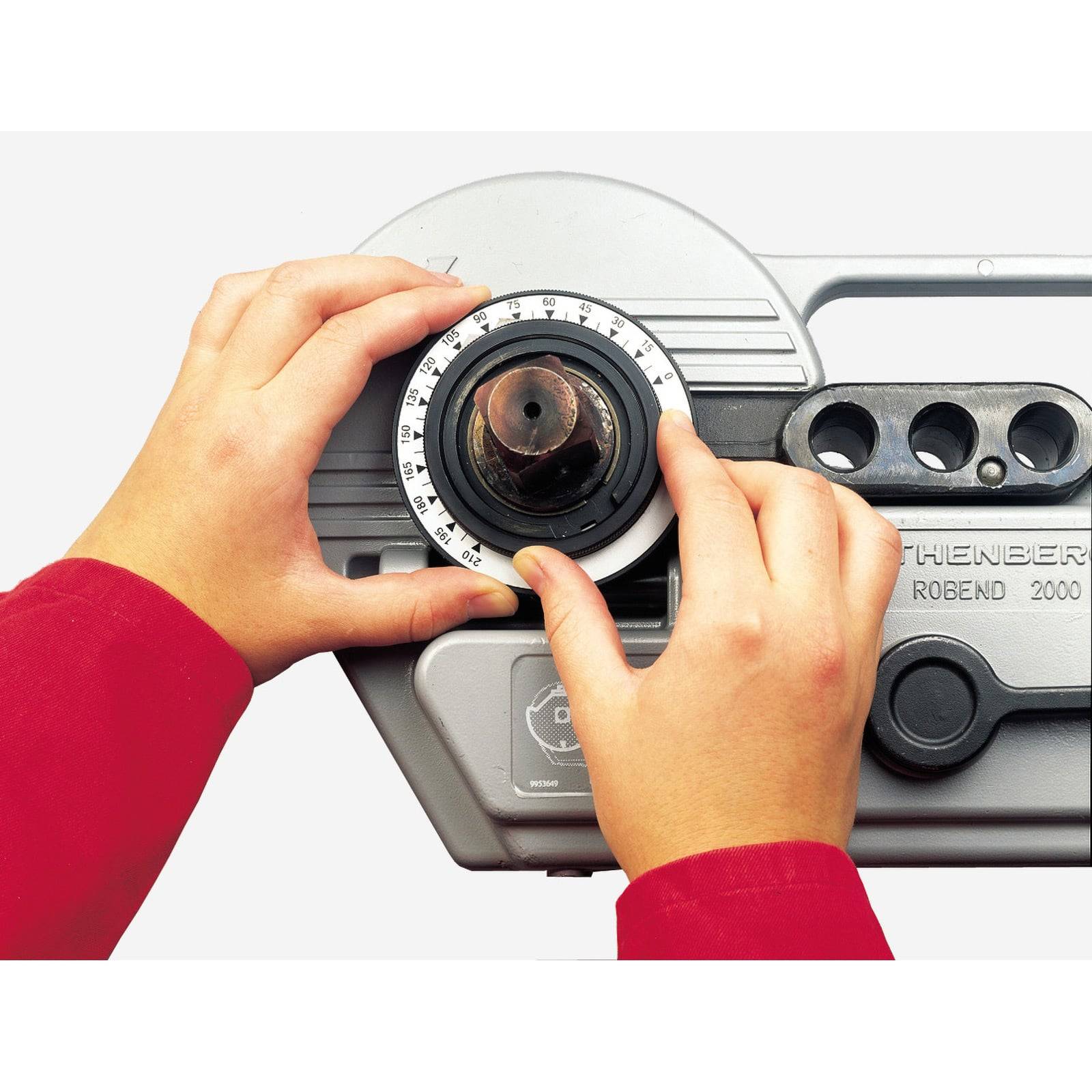 Zwei Hände justieren den Einstellknopf an einer ROTHENBERGER Rohrbiegermaschine, Modell ROBEND 2000.