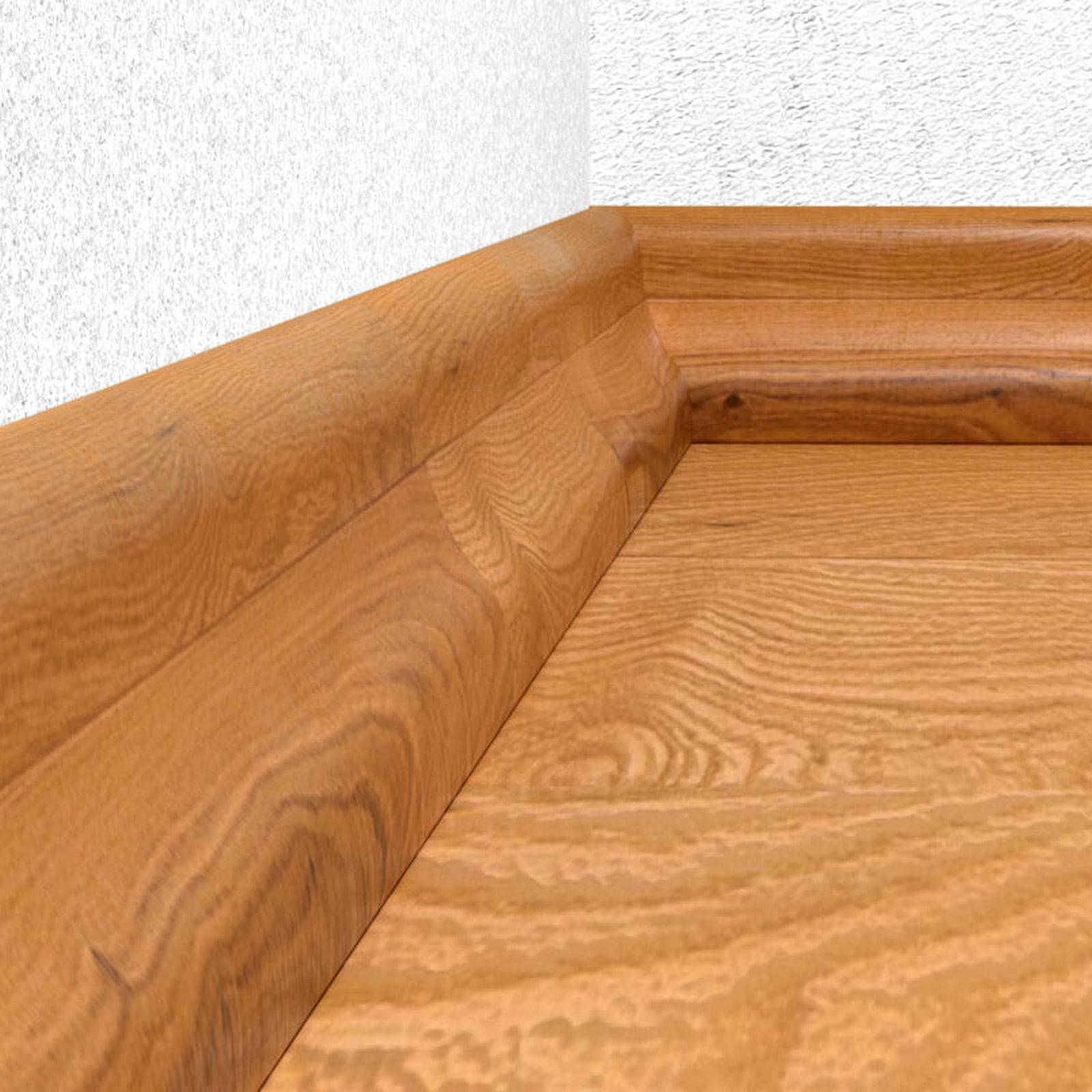 Eine Ecke eines Raumes, die einen holzfarbenen Boden und eine Sockelleiste präsentiert, wobei die Holzmaserung vor einer schlichten weißen Wand hervorgehoben wird.