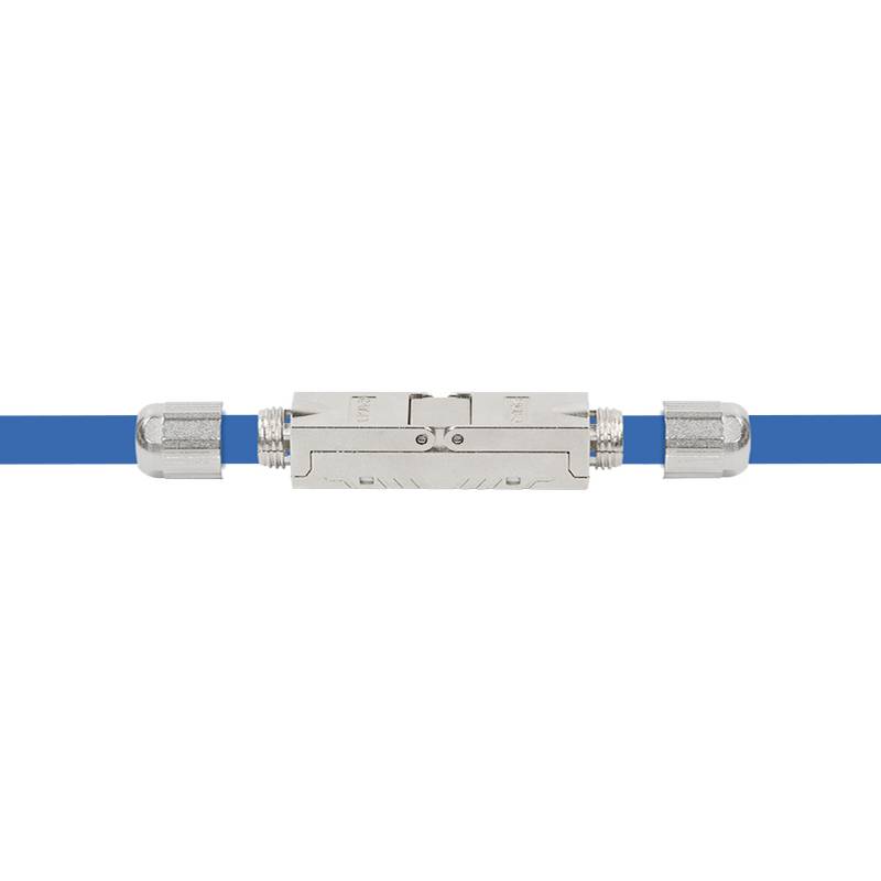 Metallischer koaxialer Kabelkuppler, der zwei blaue Kabel verbindet, zentriert auf weißem Hintergrund.
