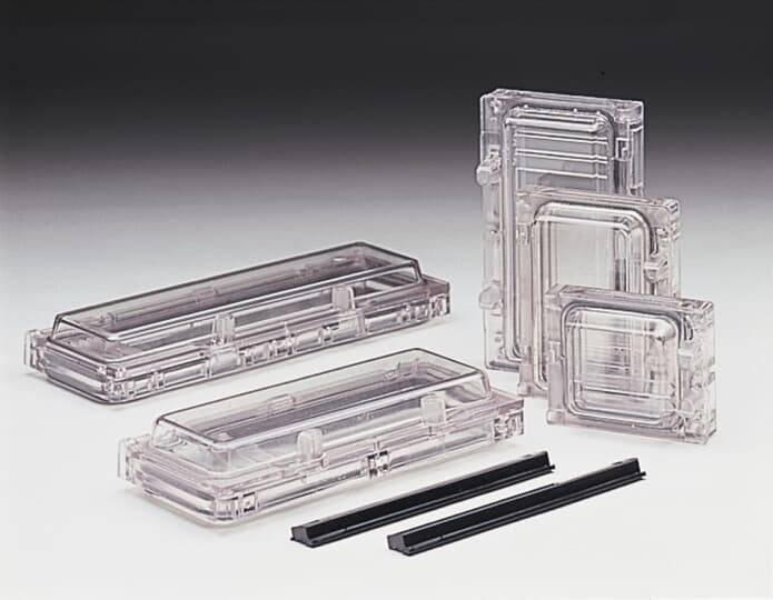 Transparente Kunststoffbehälter und schwarze Halterungen sind auf einer hellen Oberfläche angeordnet und zeigen verschiedene Größen und Formen zur organisatorischen Verwendung.