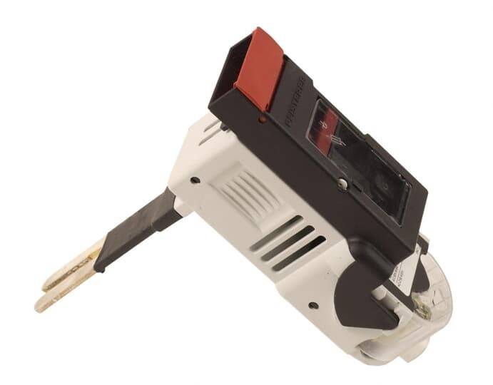 Ein Sicherungsautomat mit einem roten Schalter, der sich in der 'Aus'-Position befindet, ist auf einer Oberfläche montiert mit angeschlossenen Leitungen.