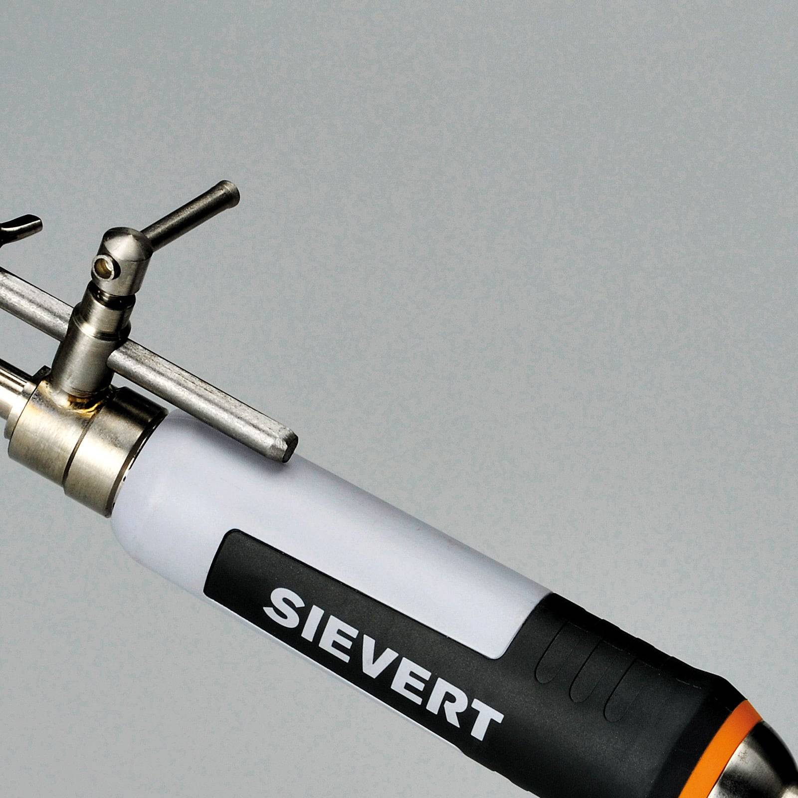 Eine Nahaufnahme einer Metalldüse einer Gasfackel mit weißem Korpus, auf dem 'Sievert' beschriftet ist, mit einem verstellbaren Ventil an der Spitze, entwickelt für präzise Heizaufgaben.