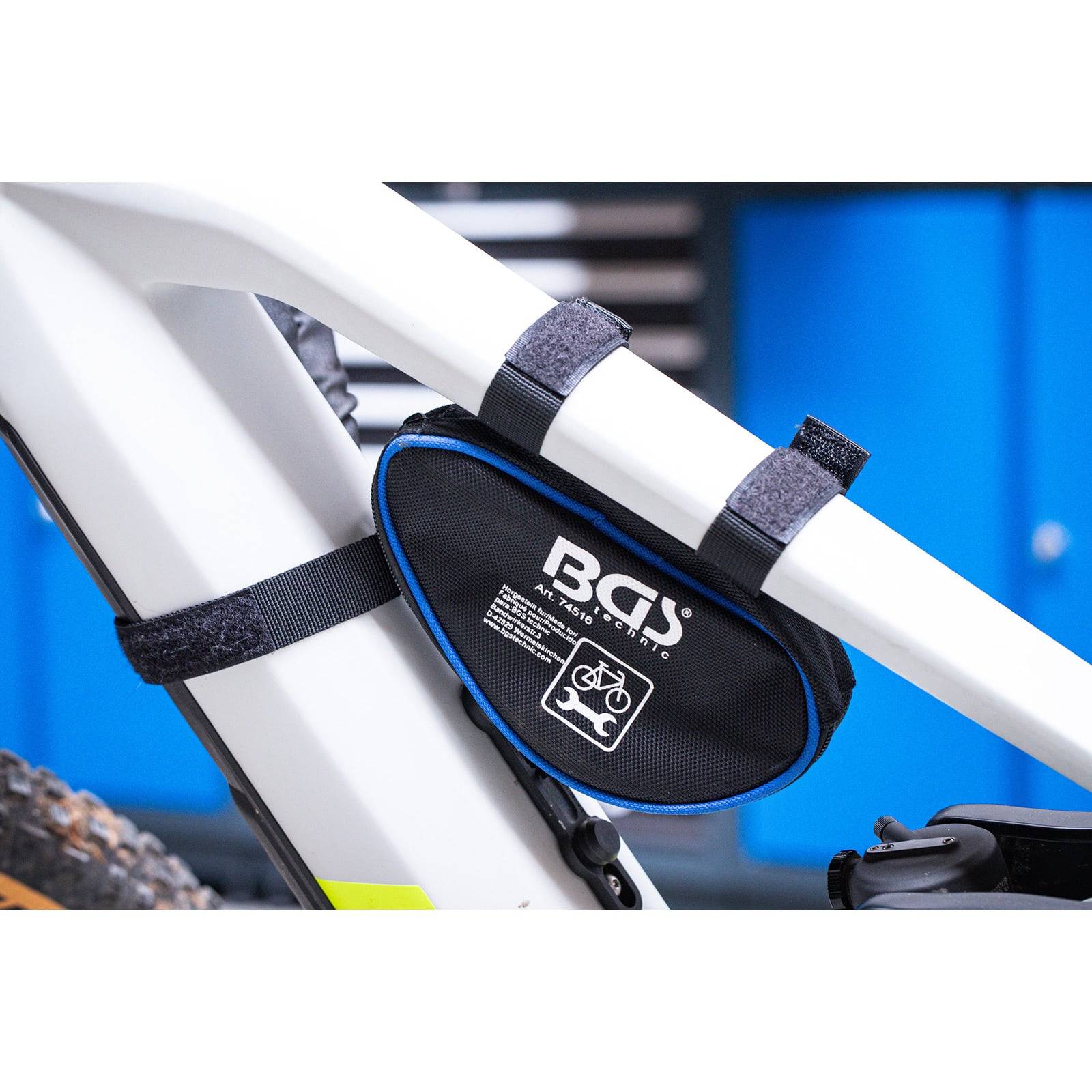 Eine kleine schwarze Fahrradtasche ist am Rahmen eines weißen Fahrrads befestigt und trägt ein 