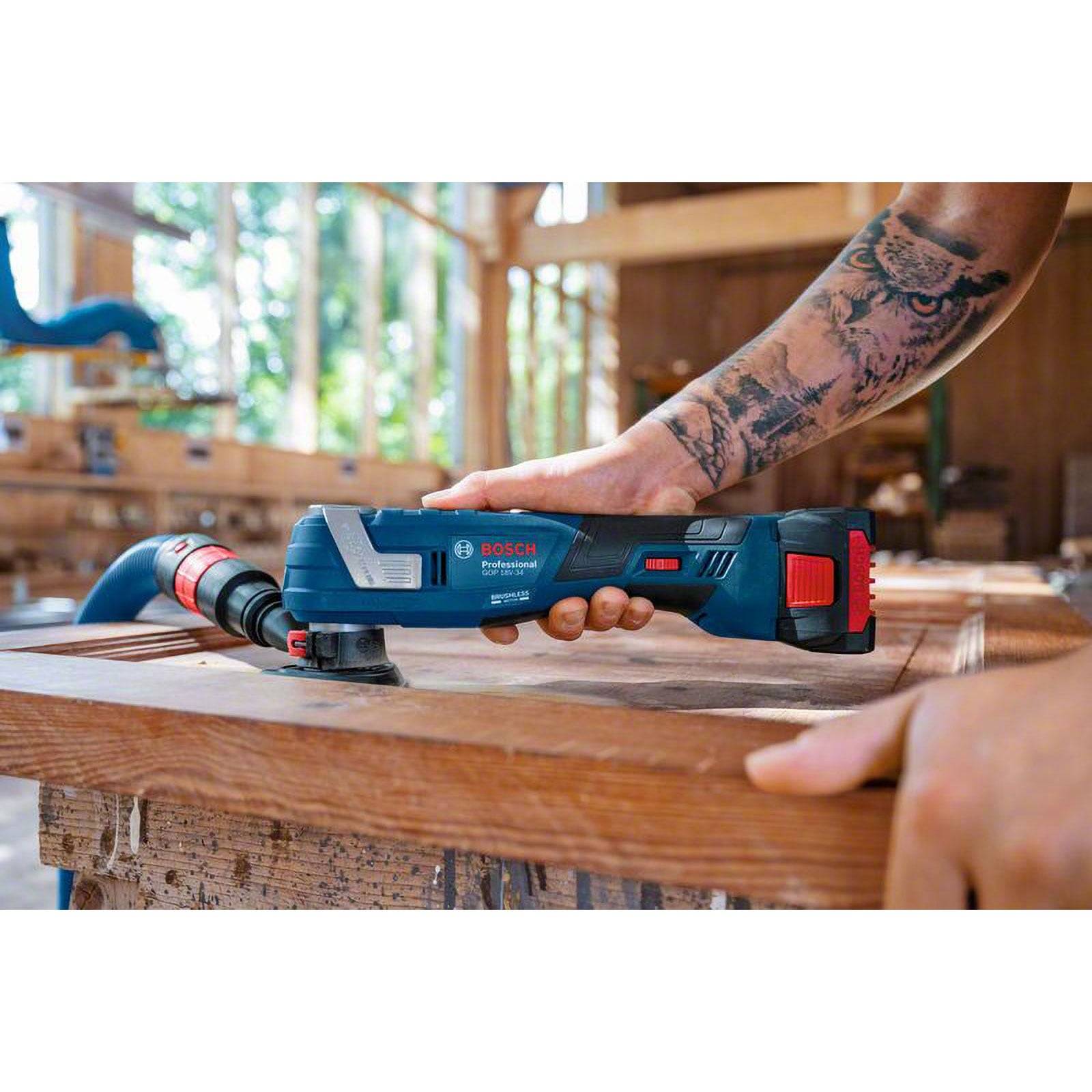 Person, die ein Bosch-Multitool auf einer Holzoberfläche in einer Werkstatt verwendet, mit Fokus auf präzisions Schneiden. Sonnenlicht filtert durch die Fenster.