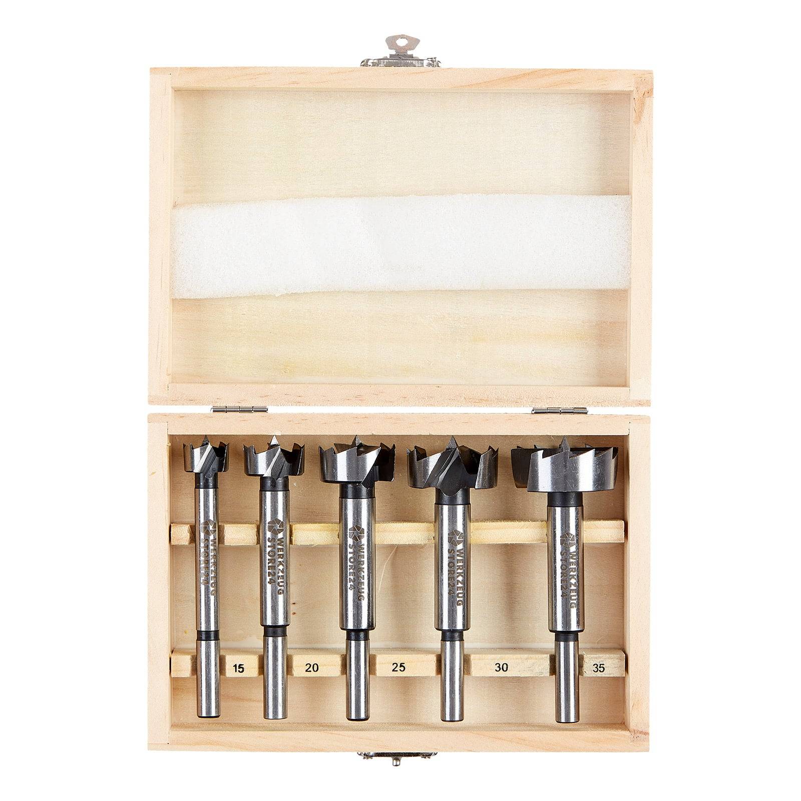 Eine Holzbox, die fünf Forstner-Bohrer verschiedener Größen (15, 20, 25, 30 und 35 mm) ordentlich in Schlitzen angeordnet enthält.