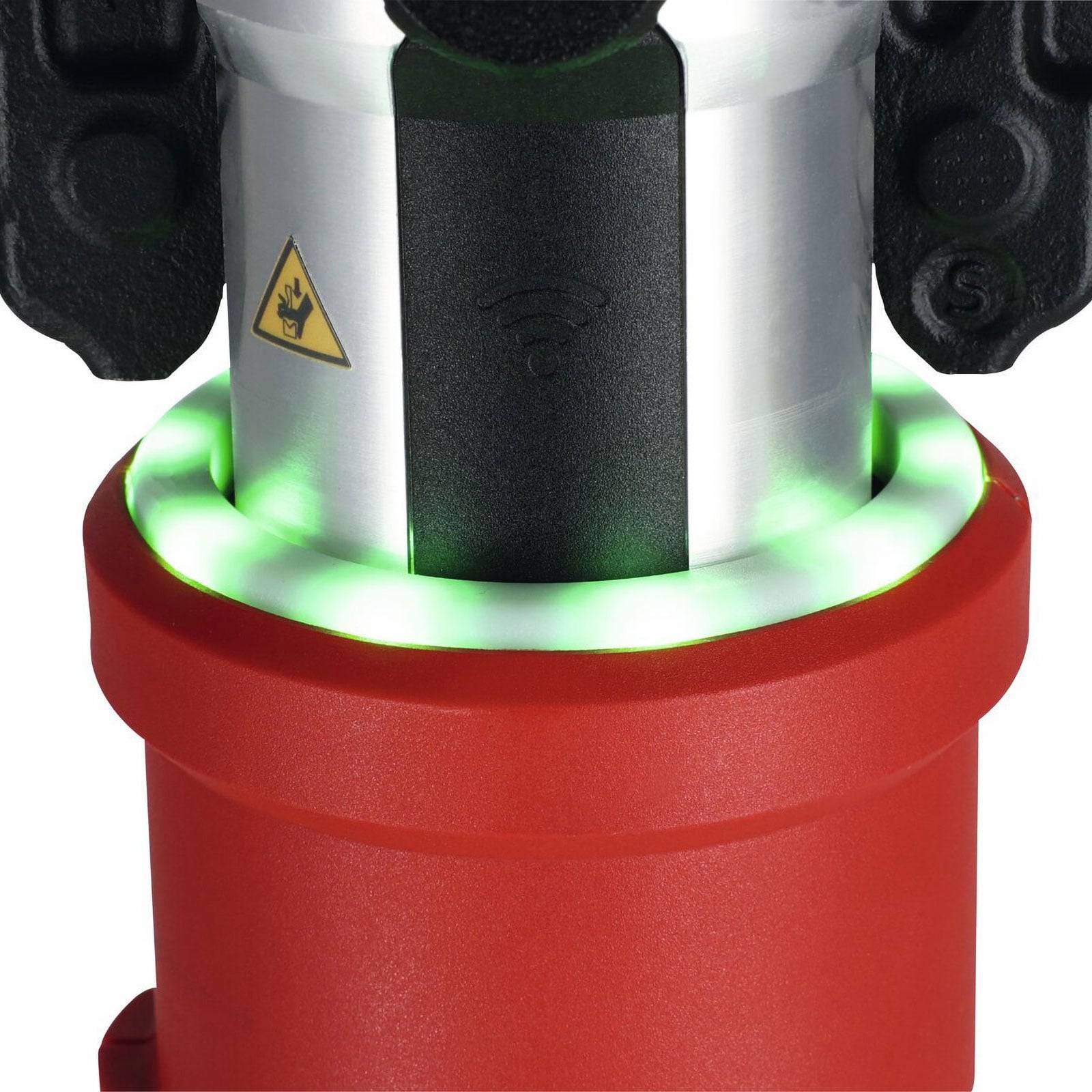 Eine Nahaufnahme eines roten und silbernen Industriegeräts mit grünen Leuchten und einem Warnzeichen, das darauf hinweist, dass es möglicherweise in Betrieb oder in Verwendung ist.