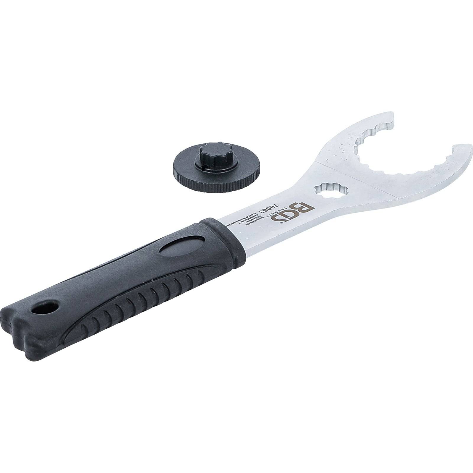 Ein Metall-Tretlager-Schraubenschlüssel mit einem schwarzen Griff, neben einem kreisförmigen Adapter, der für die Wartung und Reparatur von Fahrrädern verwendet wird.