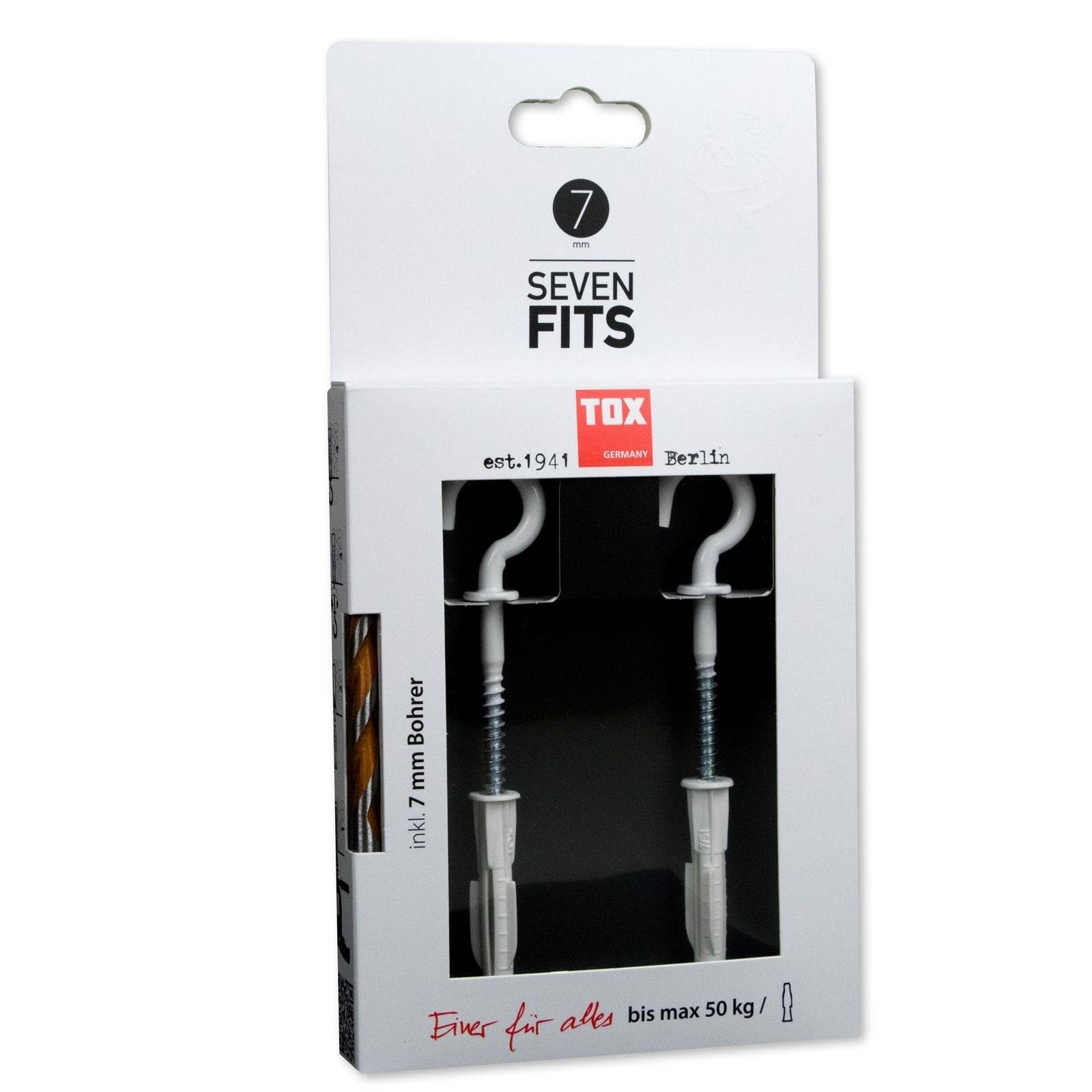 Verpackung mit zwei weißen Wandhaken mit Schrauben und Dübeln, mit der Aufschrift 'Seven Fits' und 'Tox Germany'. Text besagt 'Einer für alles bis max 50 kg'.
