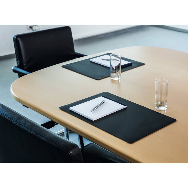Konferenztisch mit schwarzen Lederstühlen, Notizblöcken, Stiften und Wassergläsern, die ordentlich für eine Besprechung arrangiert sind.