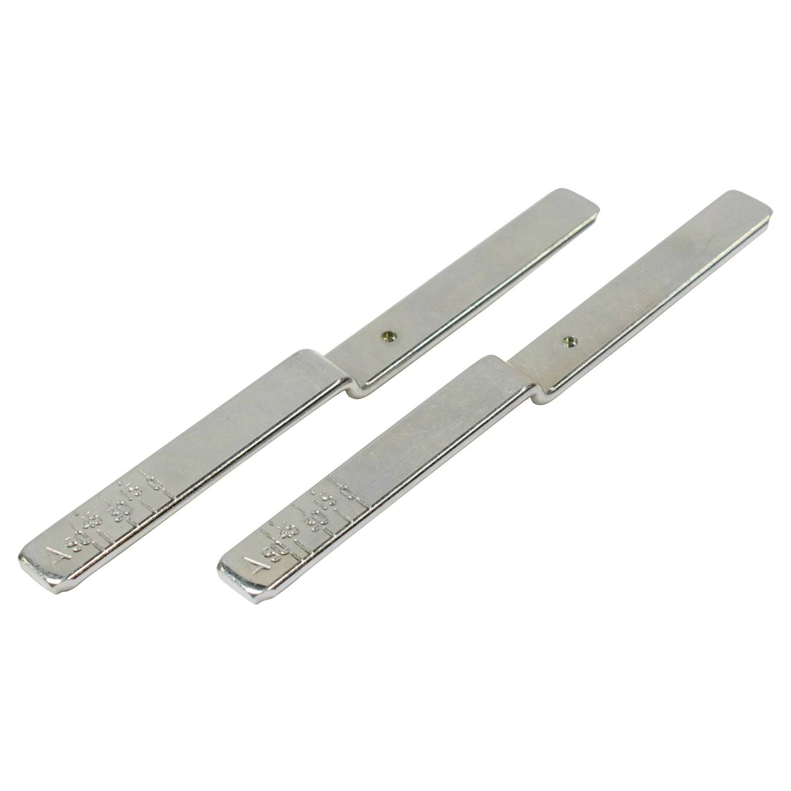 Zwei flache, rechteckige, silberfarbene Metallobjekte mit geprägten Markierungen, parallel auf einer weißen Oberfläche angeordnet.
