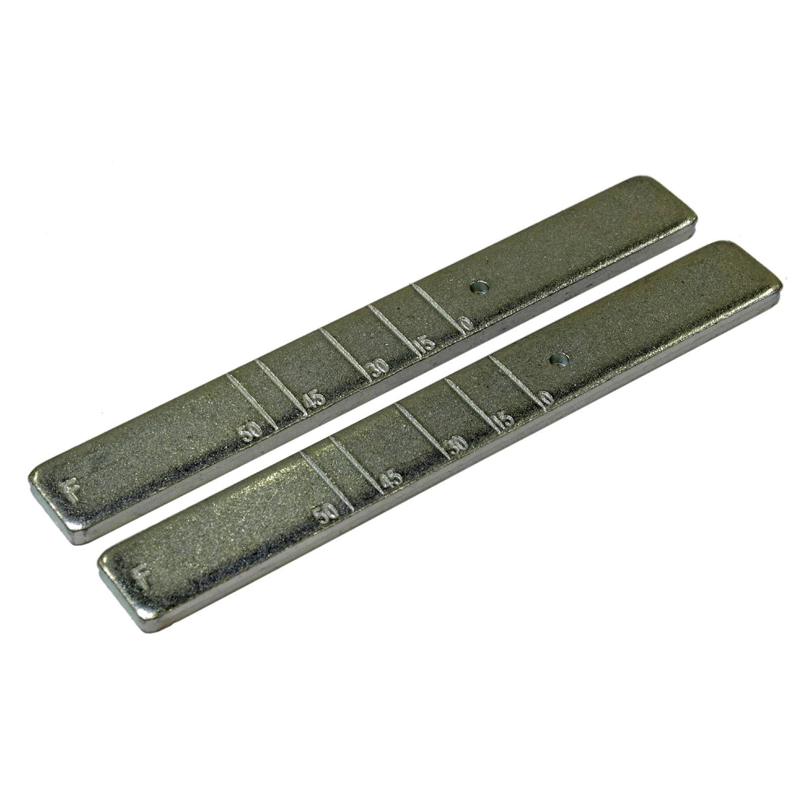 Zwei Metallgewichte mit Klebefunktion für Räder, mit Markierungen in 5-Gramm-Schritten, die zum Auswuchten von Reifen verwendet werden.