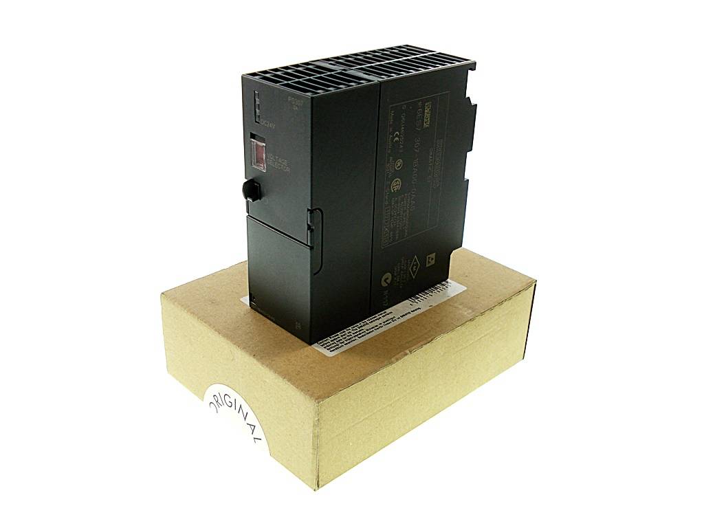 Schwarzes elektronisches Modul auf einem beigen Pappkarton vor weißem Hintergrund.