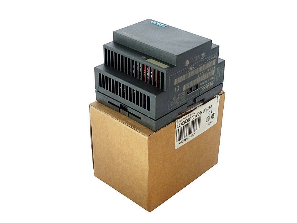 Schwarzes industrielles Elektromodul auf einem Versandkarton, freigestellt auf weißem Hintergrund dargestellt.