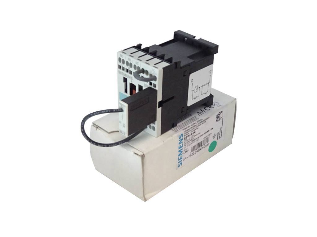 Ein elektrisches Schütz von Siemens mit angeschlossenem Kabel, das auf seiner weißen Verpackungsschachtel vor einem schlichten Hintergrund liegt.