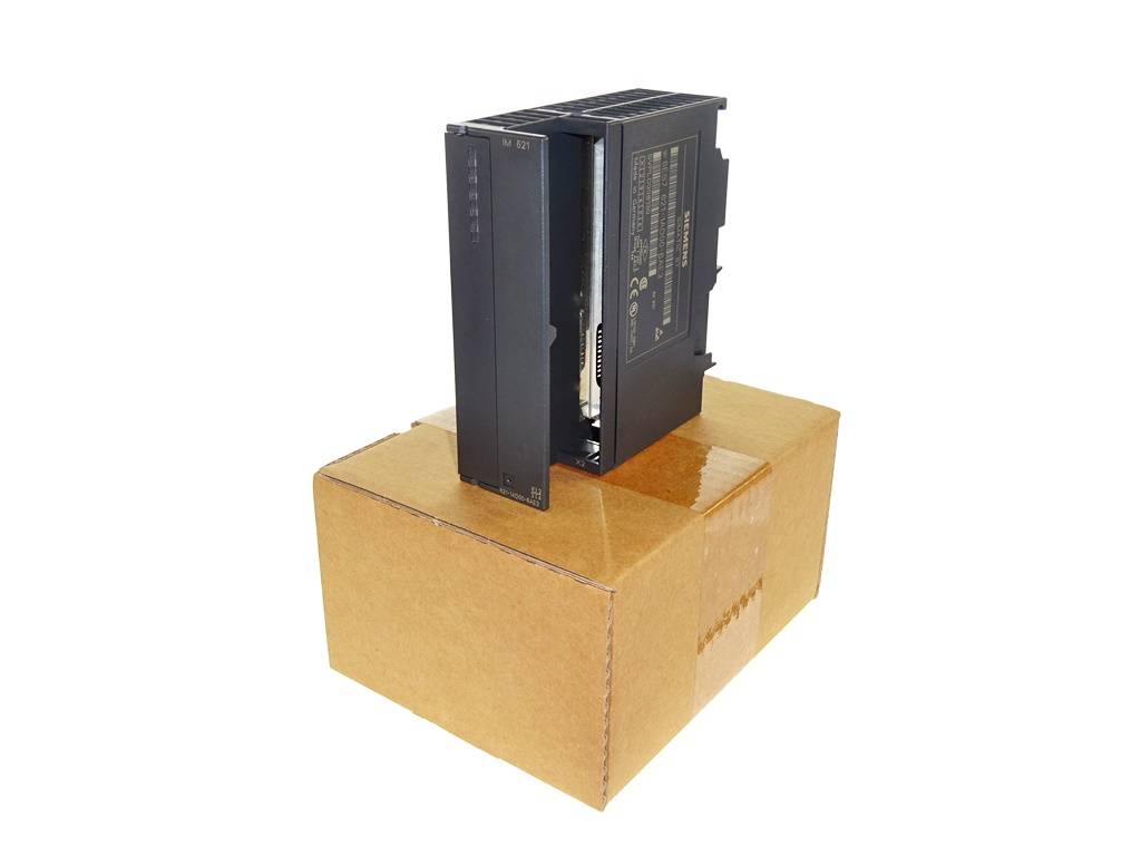 Schwarzes elektronisches Modul, aufrecht stehend auf einem verschlossenen Karton vor weißem Hintergrund.