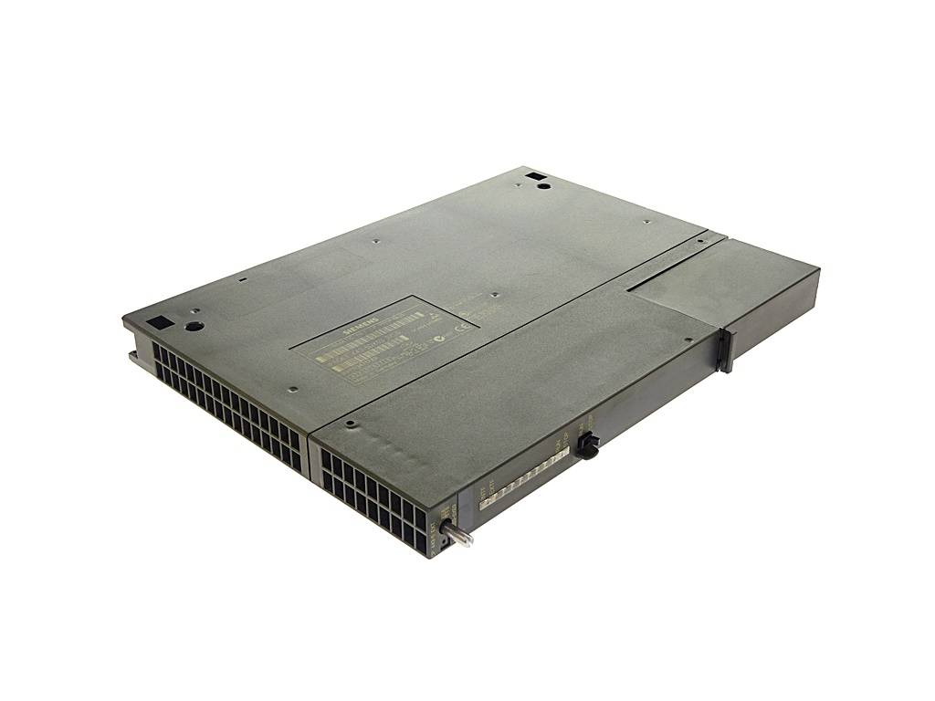 Ein graues, rechteckiges elektronisches Hardwaregerät, aus einem Winkel gezeigt, mit Lüftungsgittern und Montagebohrungen auf weißem Hintergrund.